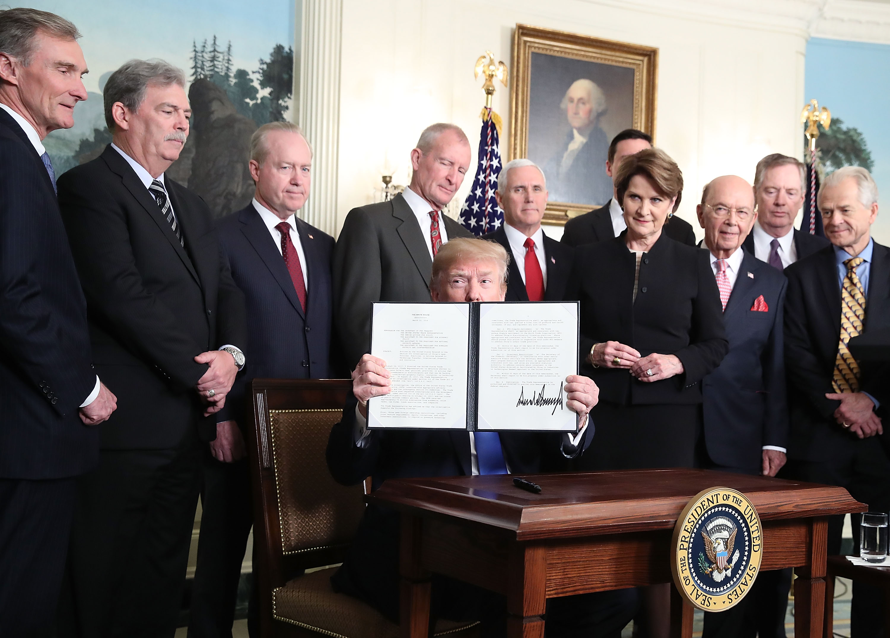 Trump holding up a signed presidential memorandum announcing tariffs against China in the Roosevelt Room at the White House on March 22, 2018. (CREDIT: Mark Wilson/Getty Images)