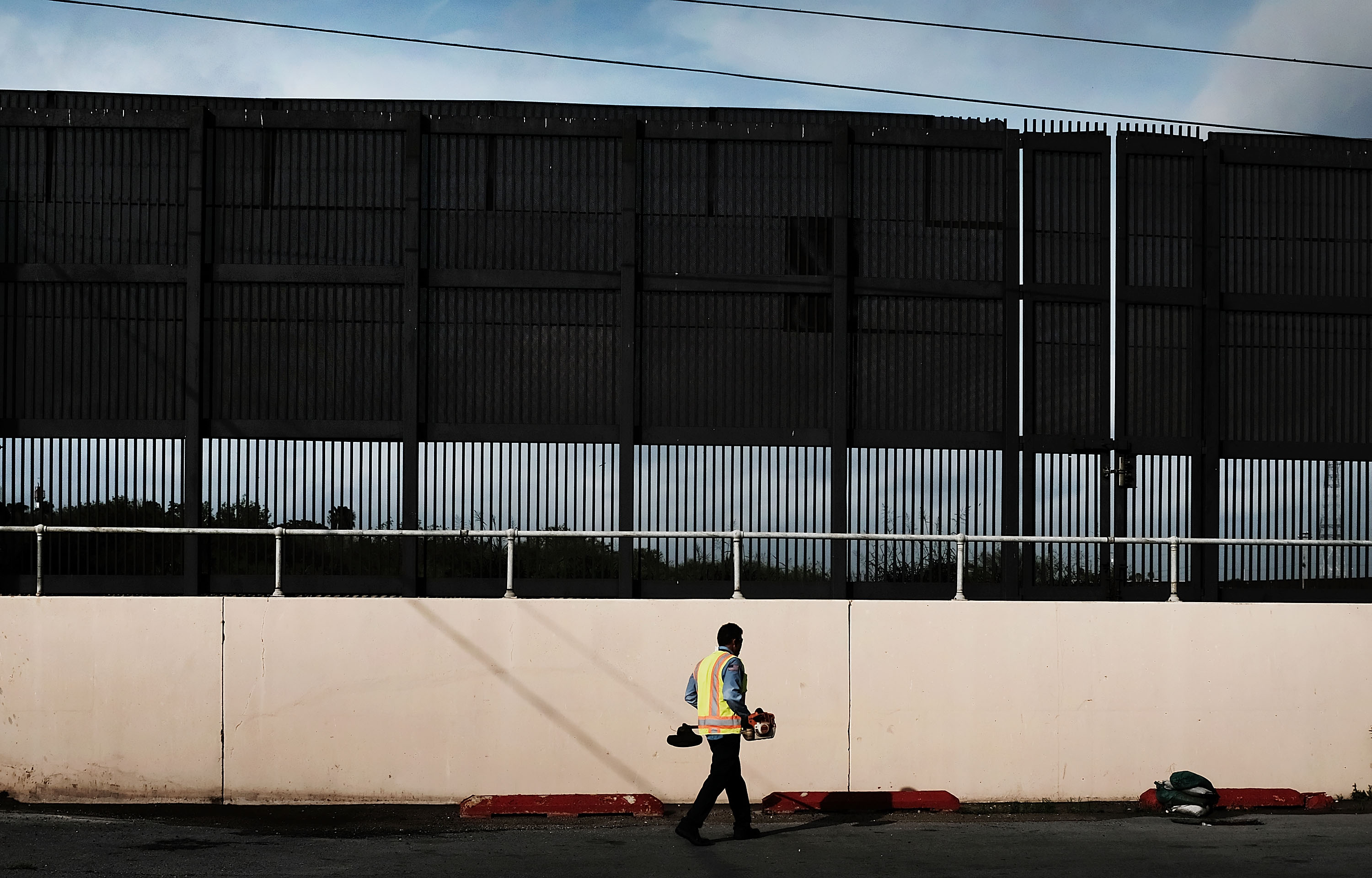 A city worker cleans an area under the border wall in downtown Brownsville, a border city which has become dependent on the daily crossing into and out of Mexico on June 22, 2018 in Brownsville, Texas. CREDIT: Spencer Platt/Getty Images