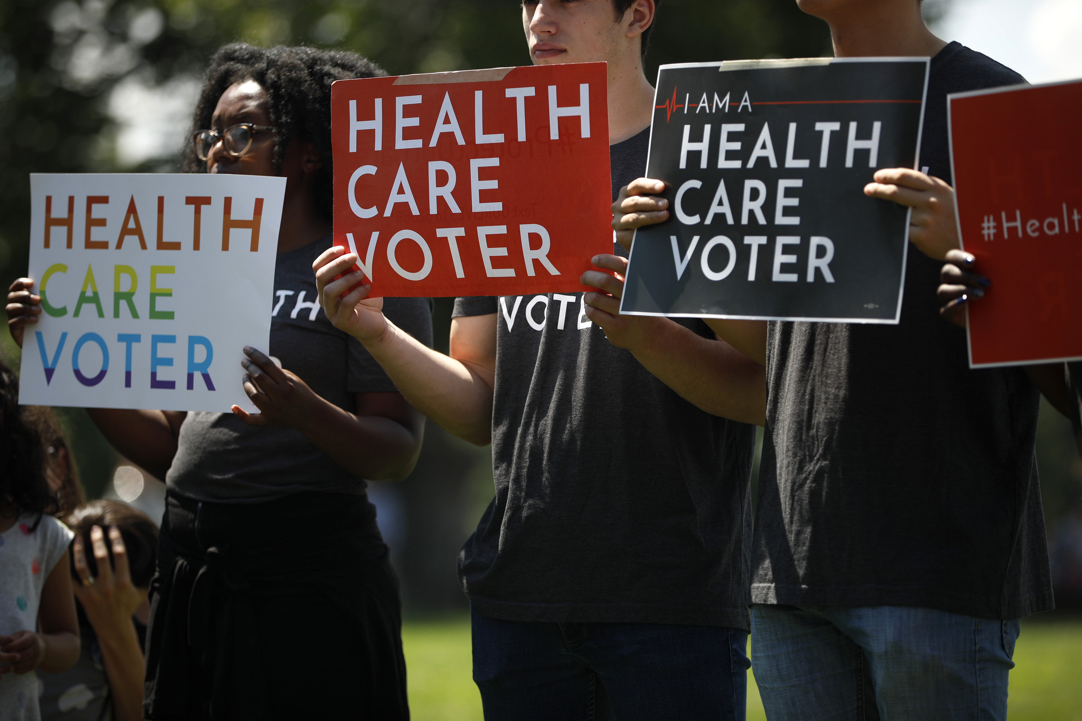 Demonstrators hold signs reading "Health Care Voter" outside the U.S. Capitol June 26, 2018 in Washington, DC. (Photo Credit: Aaron P. Bernstein/Getty Images)
