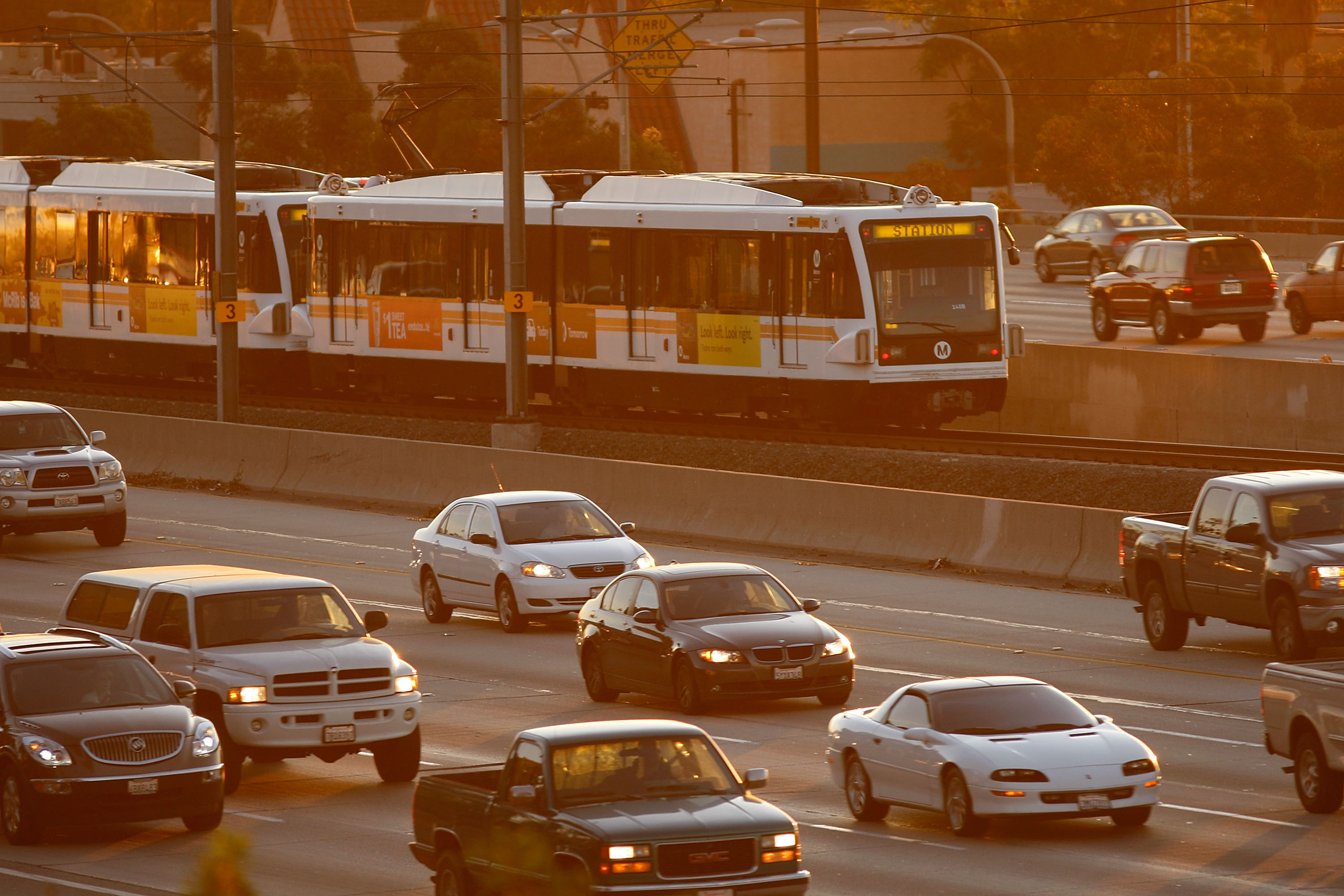 Morning commuters travel by car and train along the 210 freeway between Los Angeles and cities to the east near Pasadena, California. CREDIT: David McNew/Getty Images