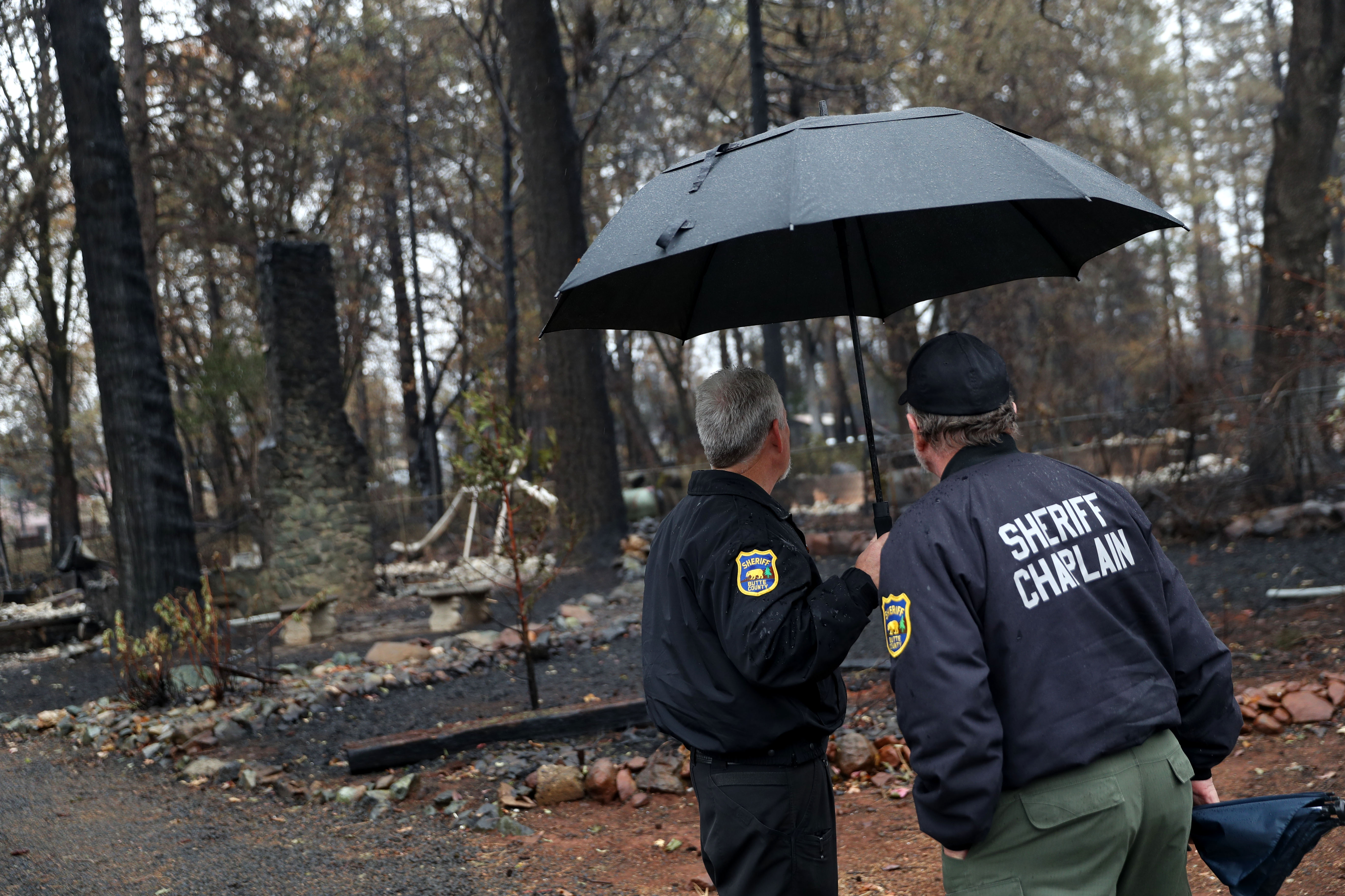 Sheriff officers stand by as crews search for human remains in homes that were destroyed by the Camp Fire on November 21, 2018 in Paradise, California. CREDIT: Justin Sullivan/Getty Images