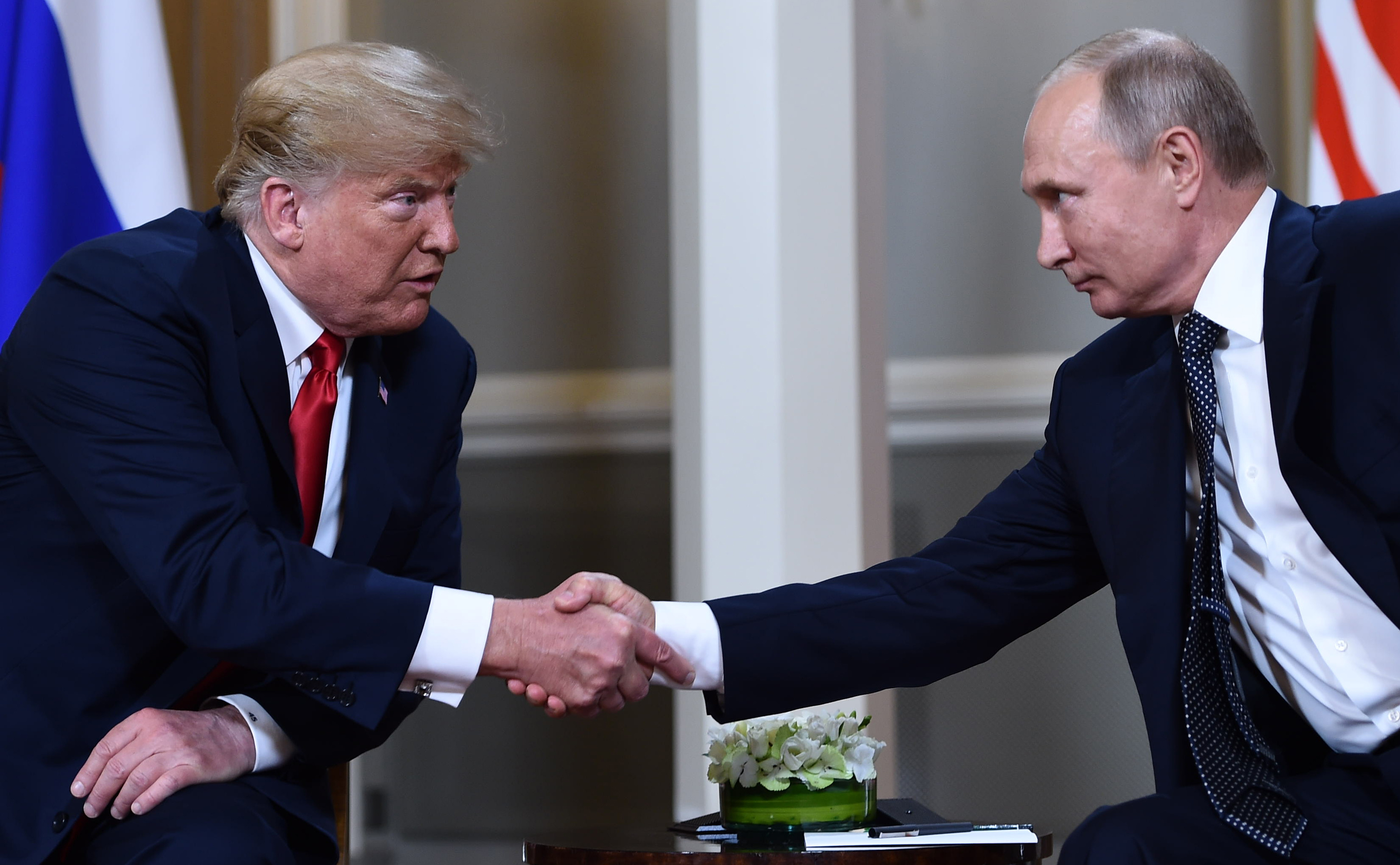 Russian President Vladimir Putin, right, and U.S. President Donald Trump shake hands before a meeting in Helsinki, Finland, on July 16, 2018. CREDIT: BRENDAN SMIALOWSKI/AFP/Getty Images