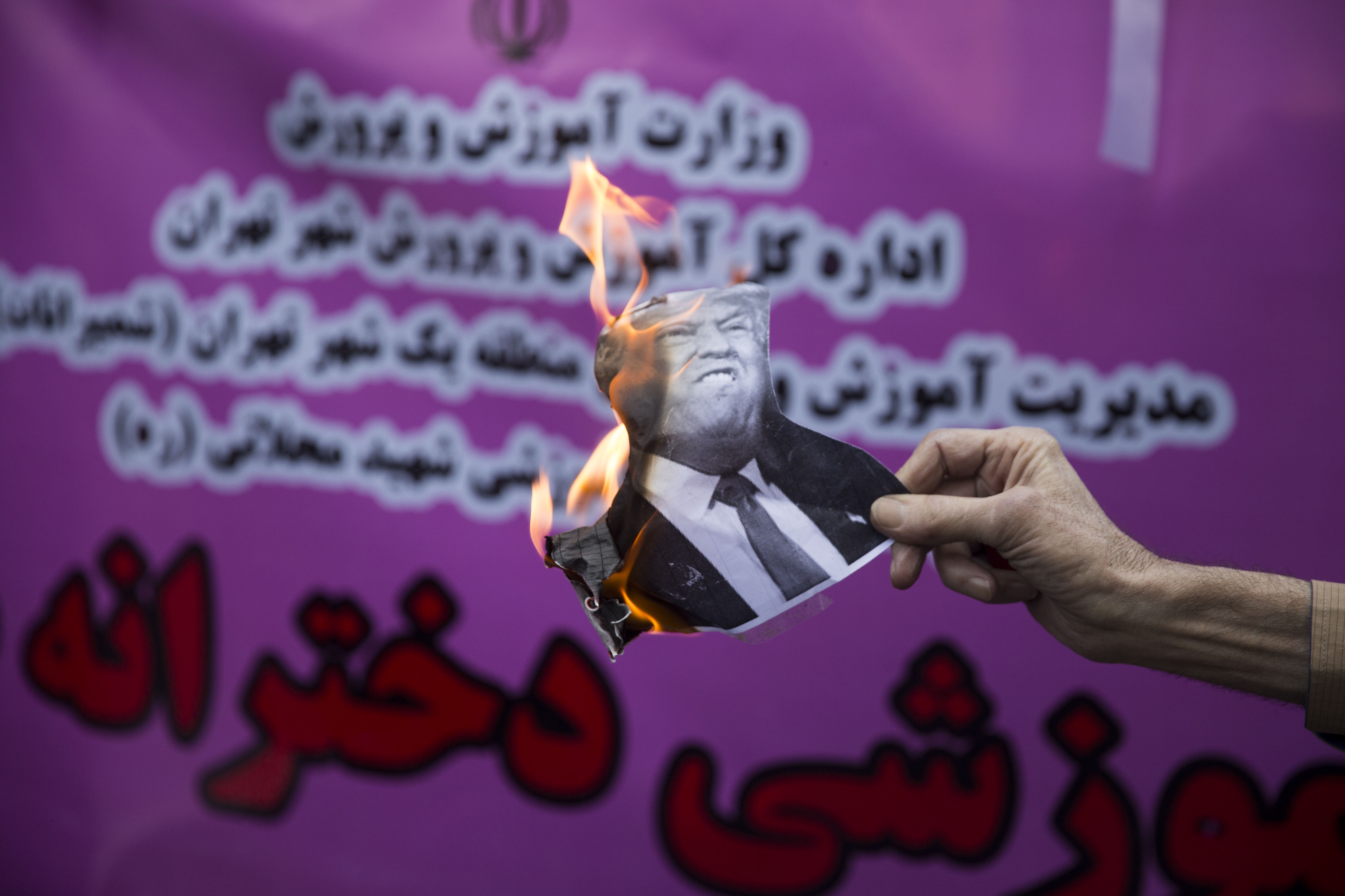 Iranian protesters burn an image of U.S. President Donald Trump during a demonstation outside the former US embassy in the Iranian capital Tehran on November 4, 2018, marking the anniversary of its storming by student protesters that triggered a hostage crisis in 1979. CREDIT: Majid Saeedi/Getty Images.
