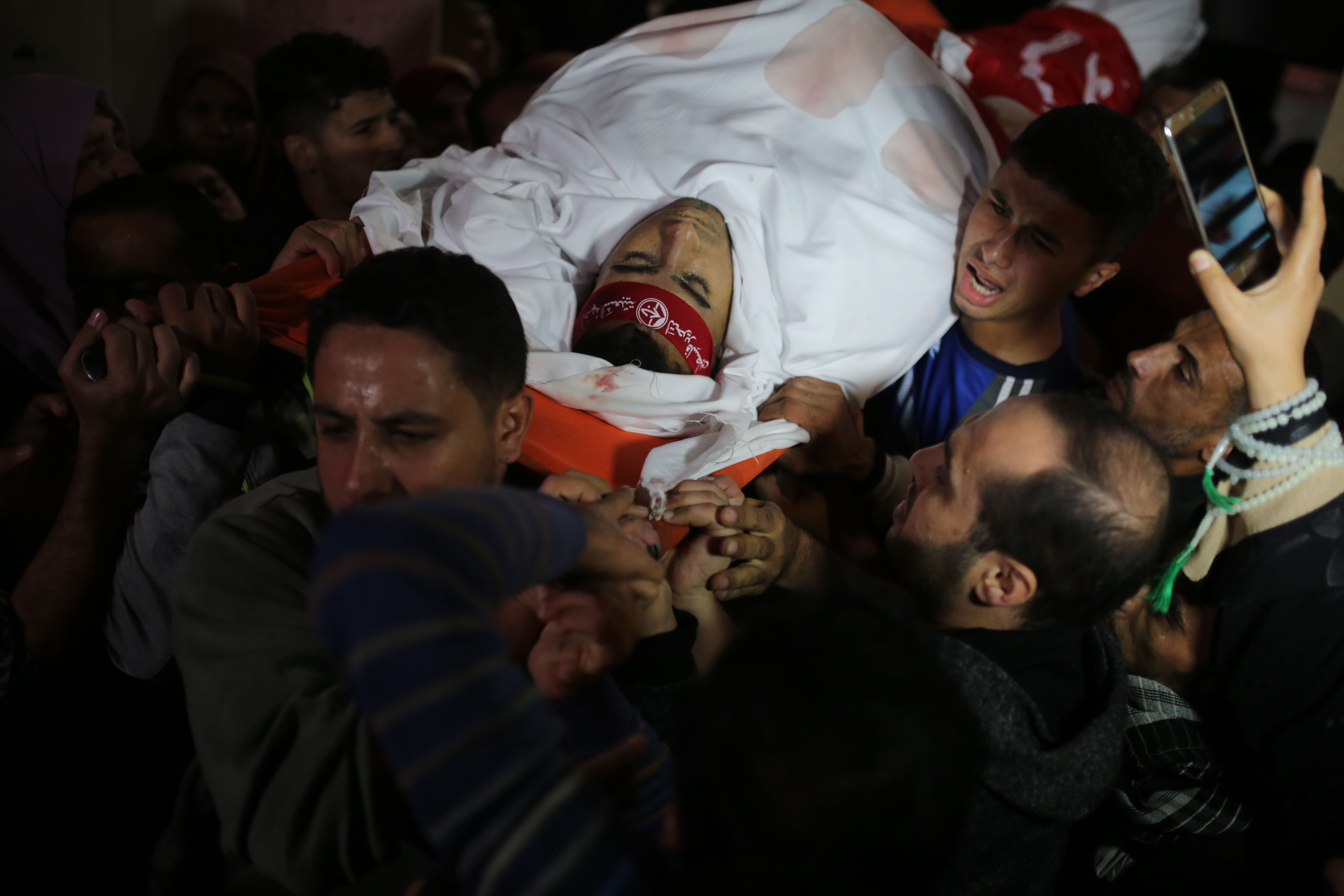 Mourners carry the body of Palestinian fighter Mohammed Al Taatri, who was killed in an Israeli air strike, during his funeral in the northern Gaza Strip November 13, 2018. CREDIT: Majdi Fathi/NurPhoto/Getty Images.