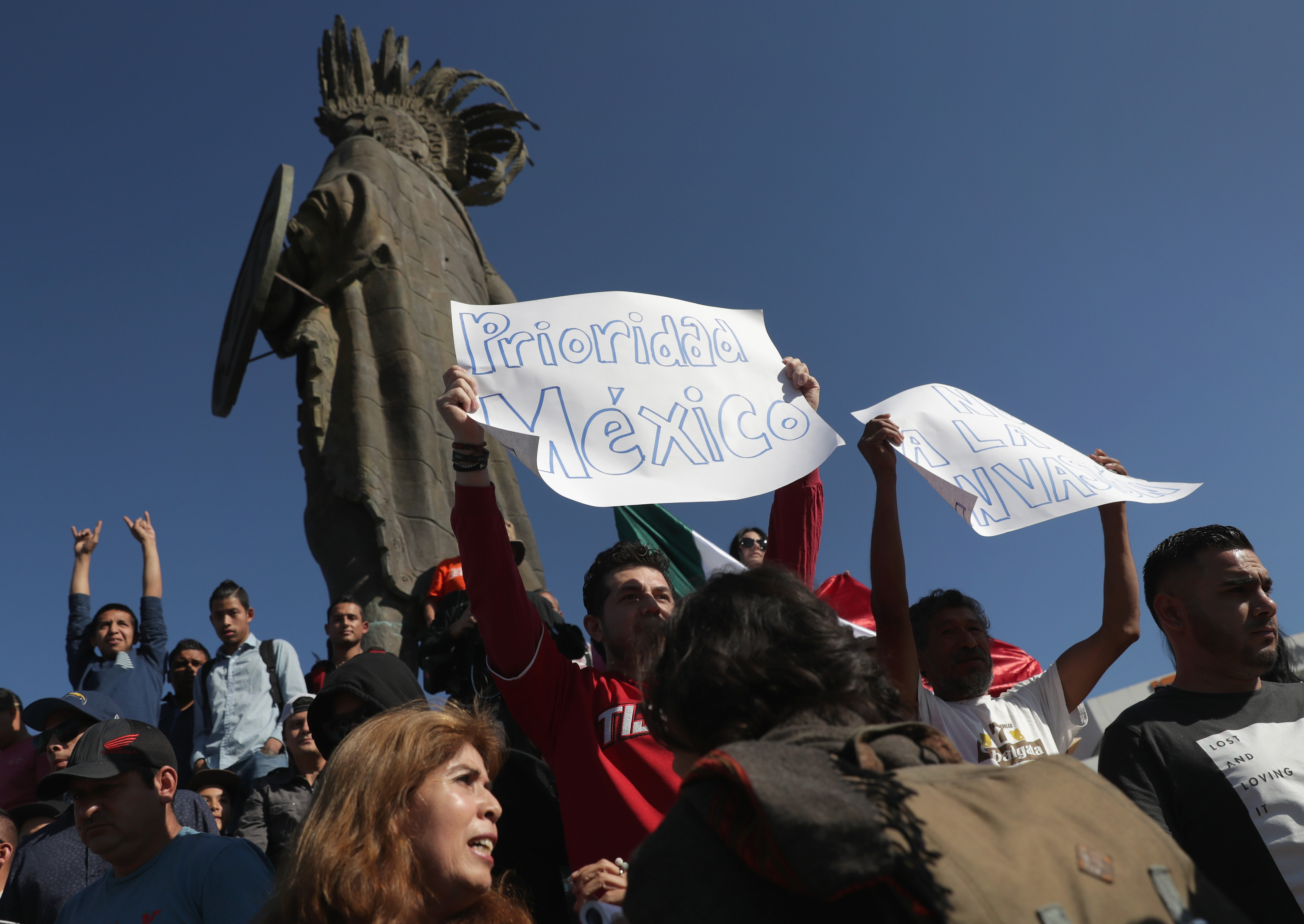 An anti-immigrant protester holds a "Mexico First!" sign before marching with fellow demonstrators to an immigrant shelter. CREDIT: John Moore/Getty Images.