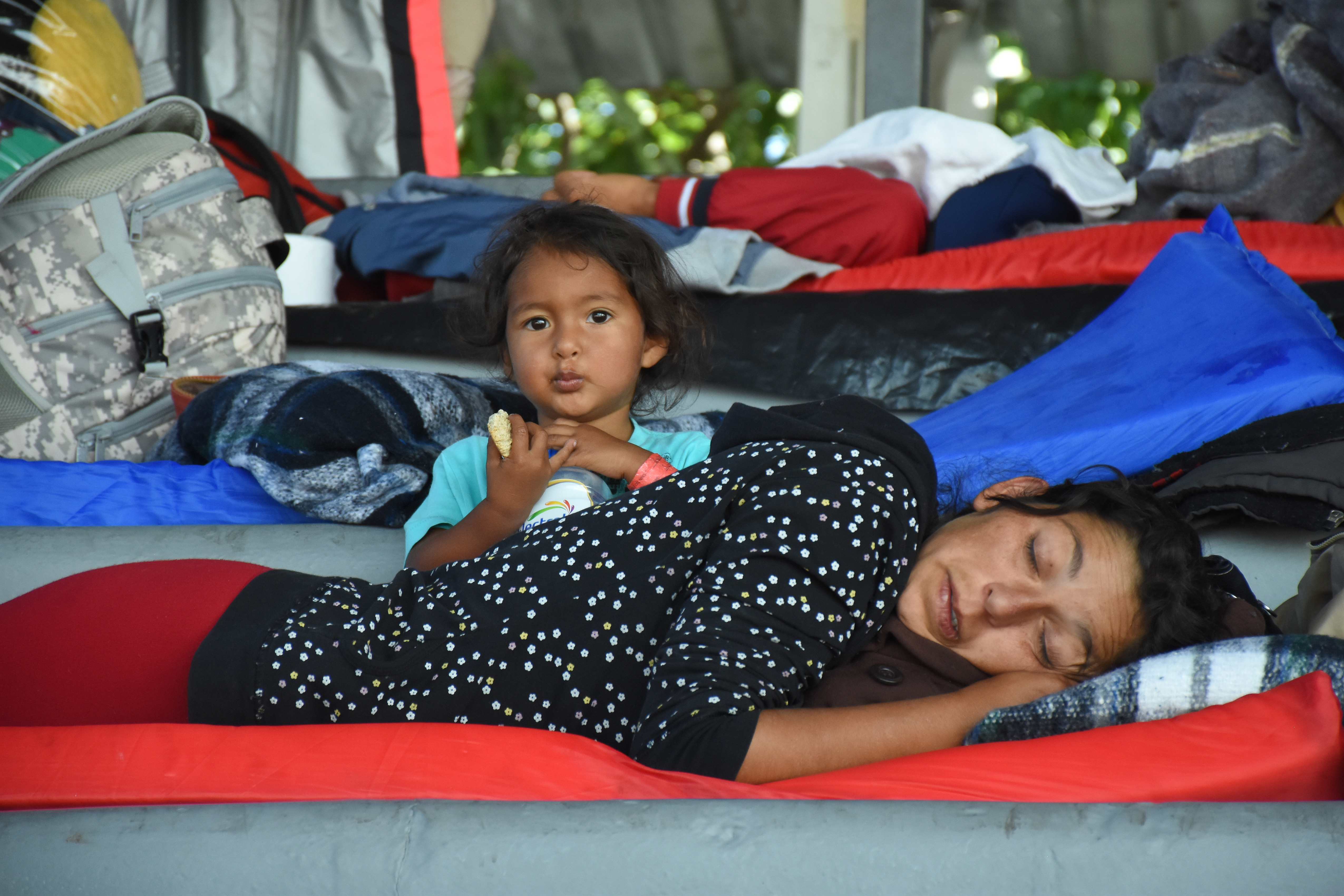 MEXICO CITY, MEXICO - NOVEMBER 09:A migrant woman sleeps next to her daughter during their stay in the temporary shelter set up by the Mexican government as hundreds of migrants rest in Mexico's capital before continuing their journey. (Photo by Carlos Tischler/Getty Images)