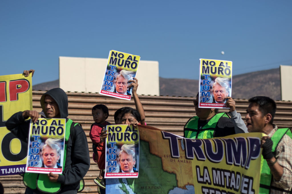 Mexican protesters hold anti-Trump and anti-border wall signs at a 2017 protest in Tijuana, Mexico.