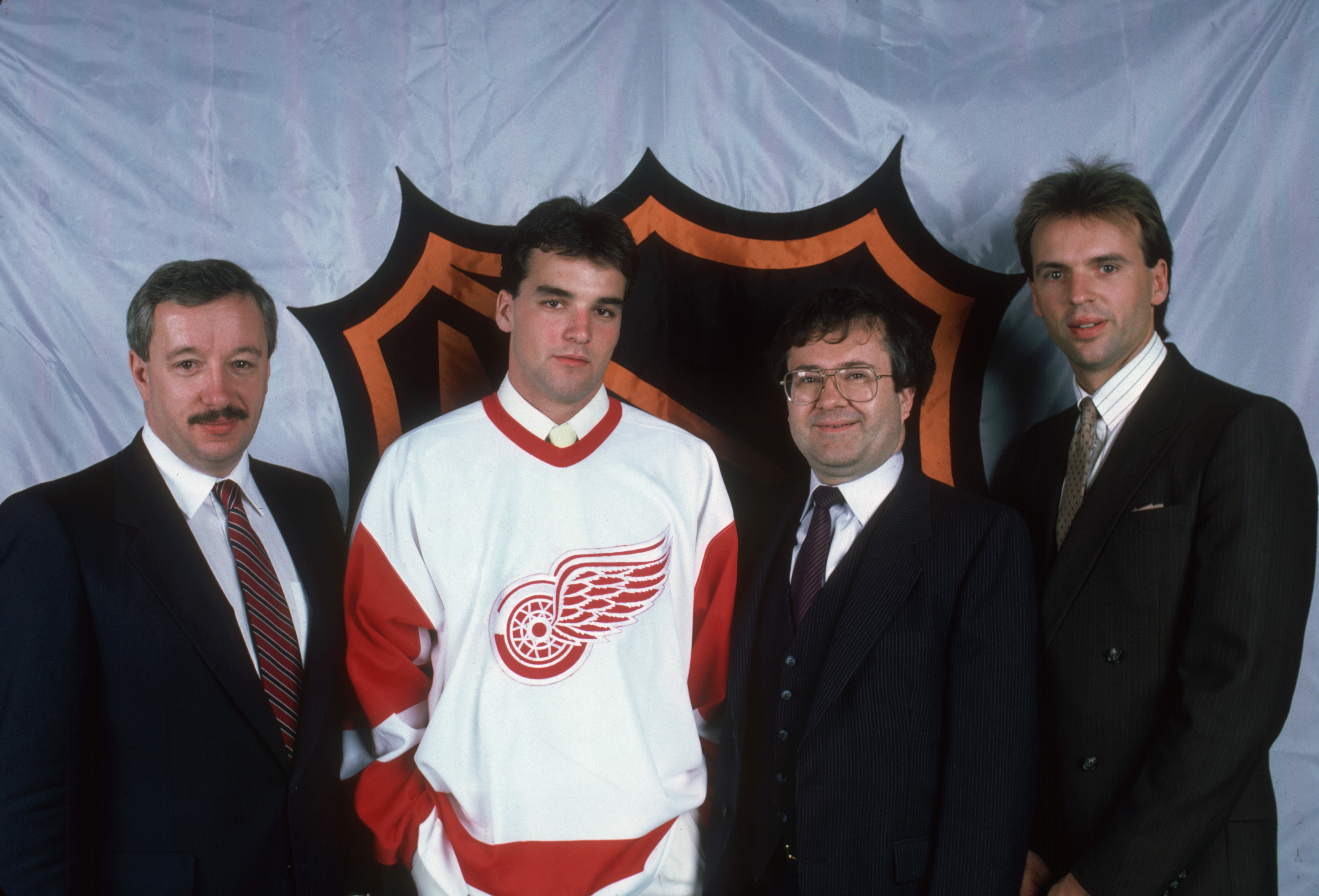 Manager of the Detroit Red Wings ice hockey team Jacques Demers (left), poses with his team's first round, first place pick, Canadian player Joe Murphy, (second left), team vice president Jim Devellano (second right), and team scout Neil Smith in the NHL Entry Draft at the Montreal Forum, Montreal, Quebec, June 21, 1986. (Photo by Bruce Bennett Studios/Getty Images)
