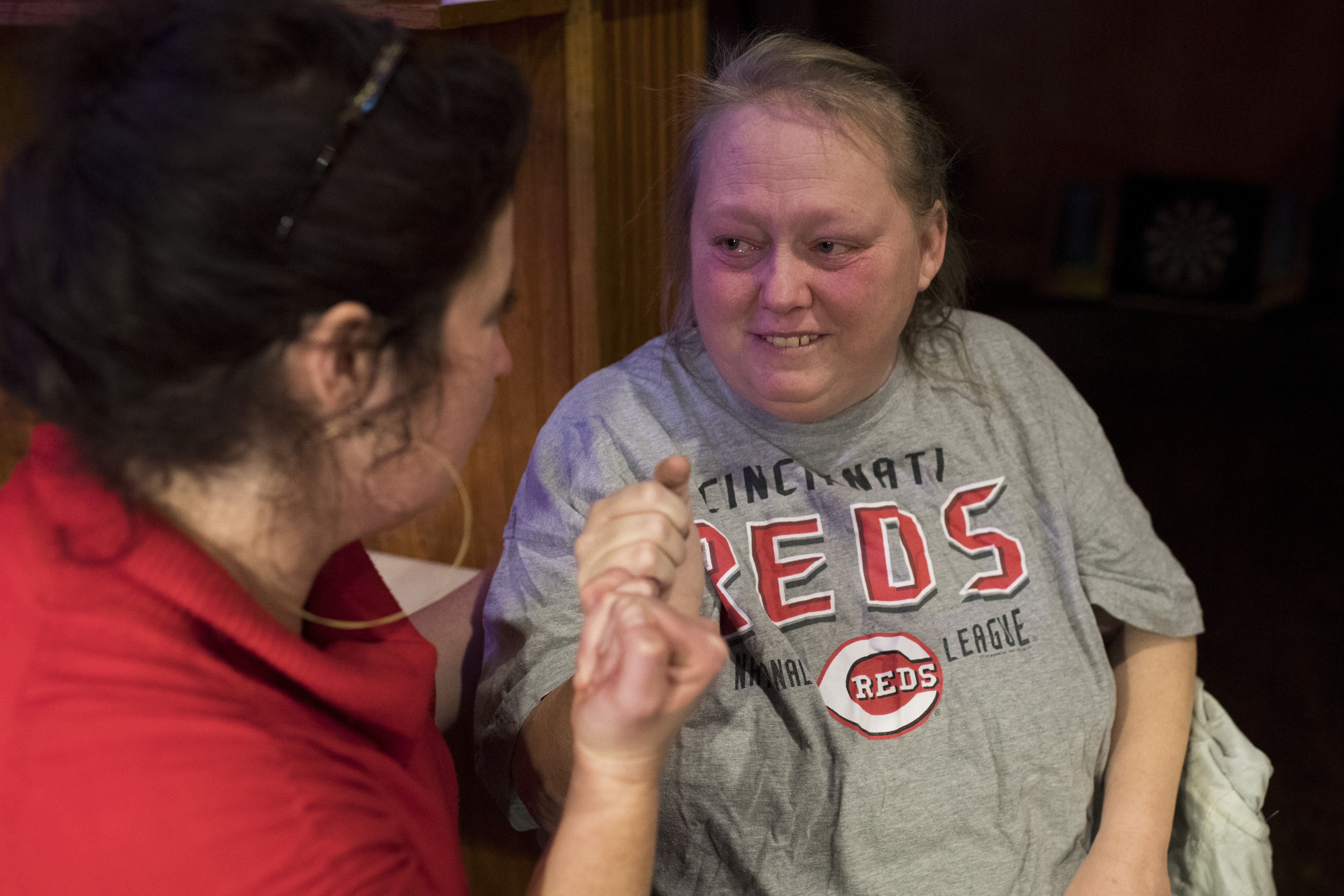 Cara Stewart, a legal advocate opposing Medicaid work requirements in Kentucky, "pinky-swears" to help Pauline Creech after they talked about Pauline's cancer coming back at Mr. T's Bar in Covington, Kentucky on January 15, 2018. (Photo Credit: Carolyn Van Houten/The Washington Post via Getty Images)