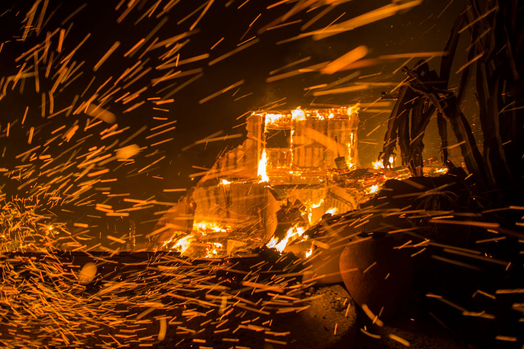 Strong winds blow embers from burning houses in Malibu, California on November 9, 2018. CREDIT: David McNew/Getty Images.