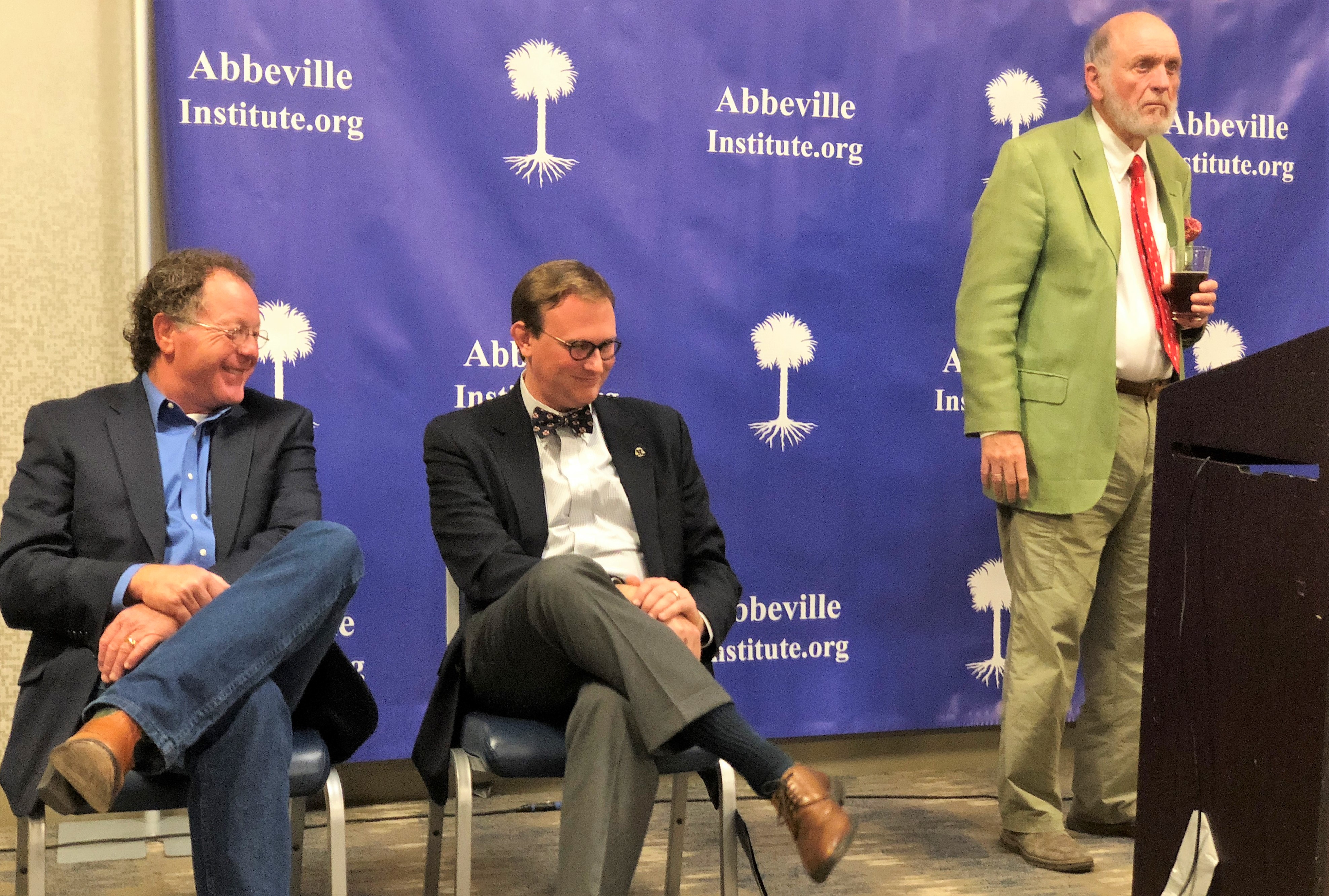 Donald Livingston (right) stares at the crowd while failed gubernatorial candidate Dan Fisher (left) and Allen Mendenhall (center), a former staff attorney for Roy Moore, laugh on Saturday. CREDIT: CASEY MICHEL