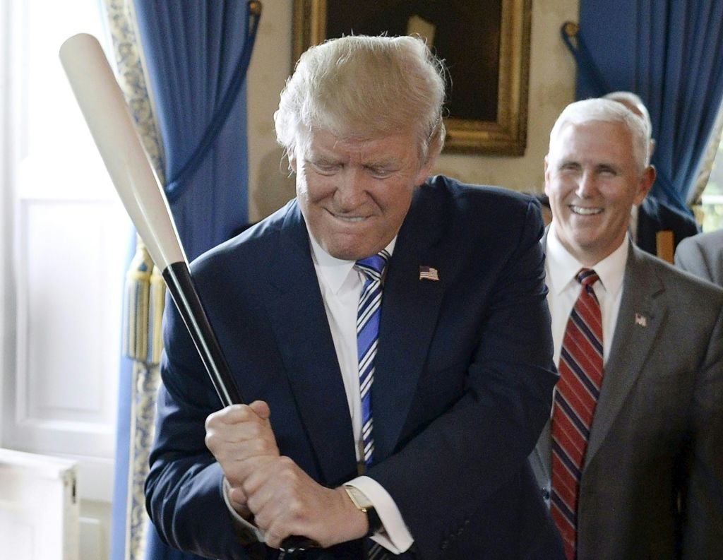Donald Trump swings a baseball bat as Mike Pence watches in the White House on July 17, 2017. (OLIVIER DOULIERY/AFP/Getty Images)