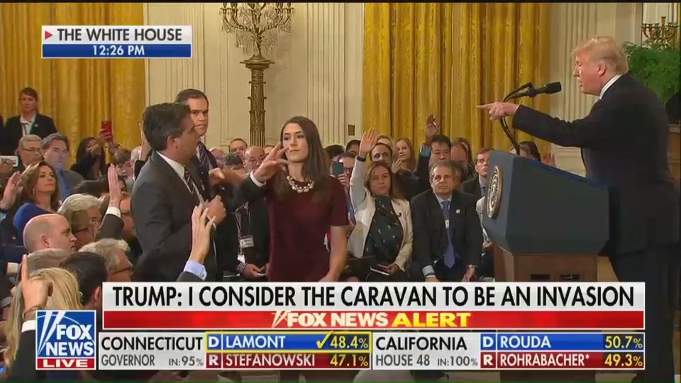 A White House aide attempts to grab a microphone from CNN reporter Jim Acosta's hands during a press conference. The White House has since issued an allegedly doctored video of the live broadcast, accusing Acosta of assaulting the woman. Original footage does not support their claim. (PHOTO CREDIT: Fox News, screengrab)