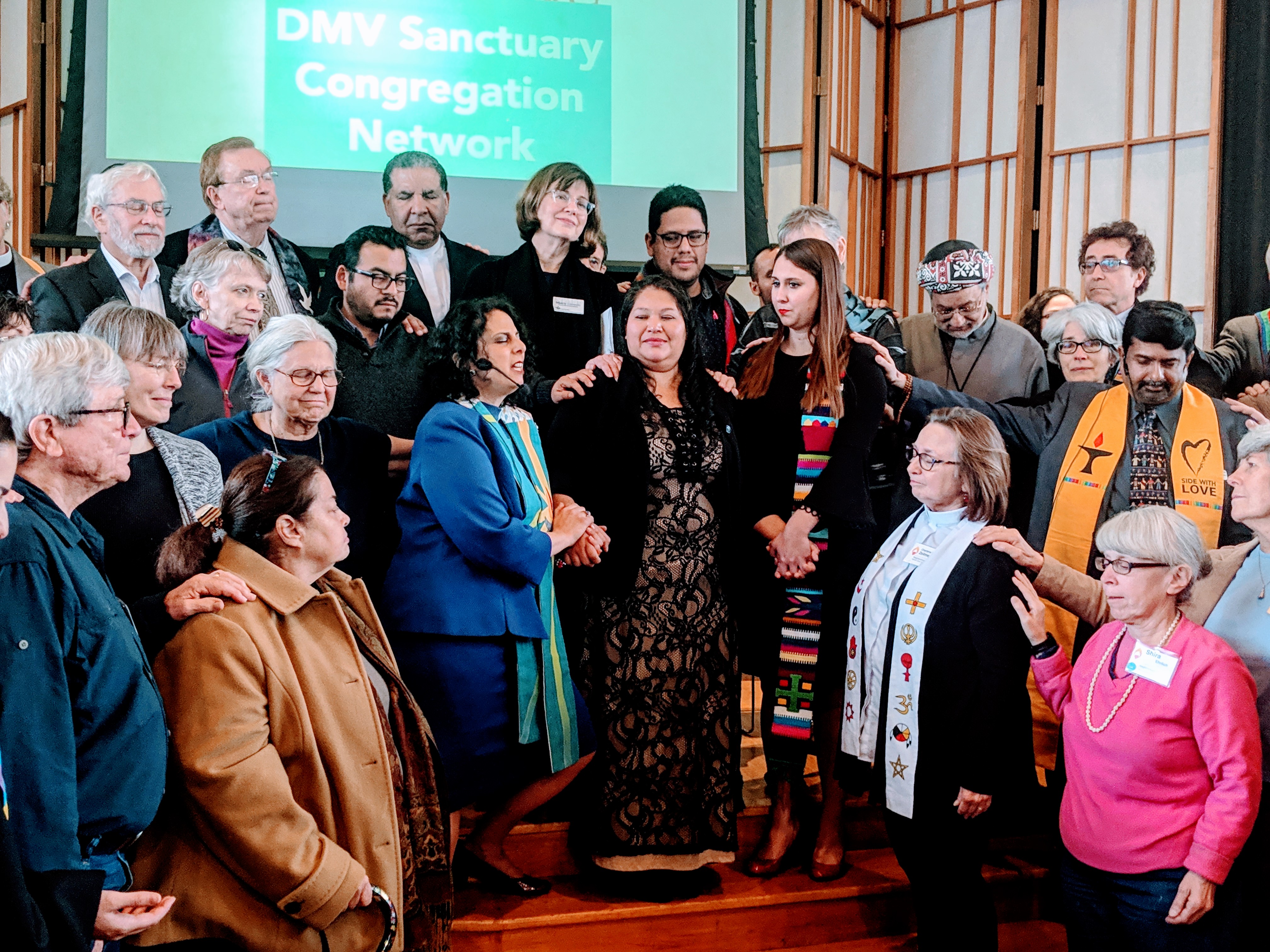 Clergy and congregants welcome Rosa Gutierrez Lopez, center, to sanctuary at the Cedar Lane Unitarian Universalist Church in Maryland after federal immigration officials tried to force her back to El Salvador. Gutierrez Lopez has no criminal record, and the youngest of her three U.S.-born children has Down Syndrome. CREDIT: Alan Pyke/ThinkProgress