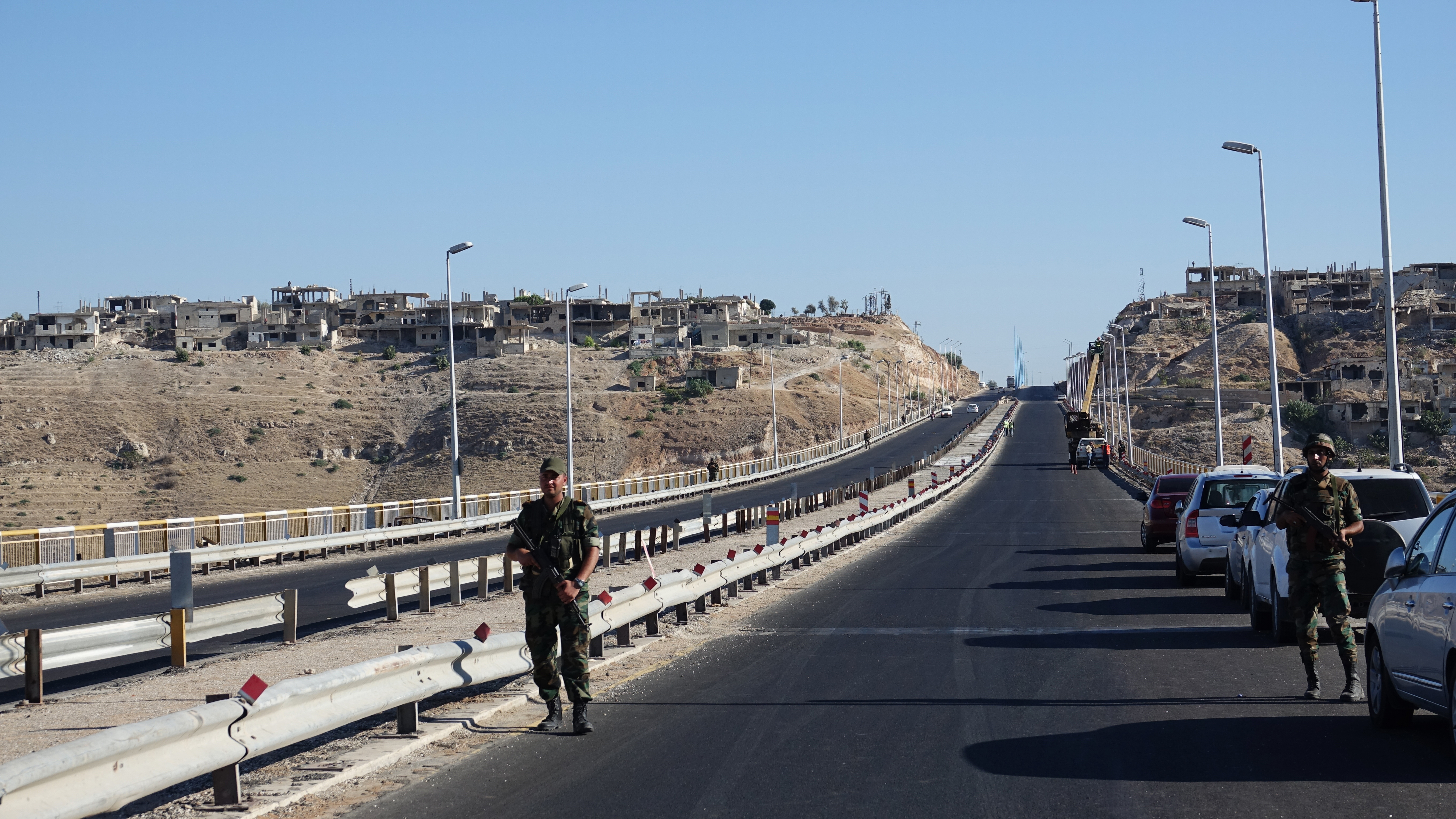 Soldiers stand on the bridge of Rastan at the highway 5 Damascus-Aleppo. (Photo Credit: Friedemann Kohler/picture alliance via Getty Images)