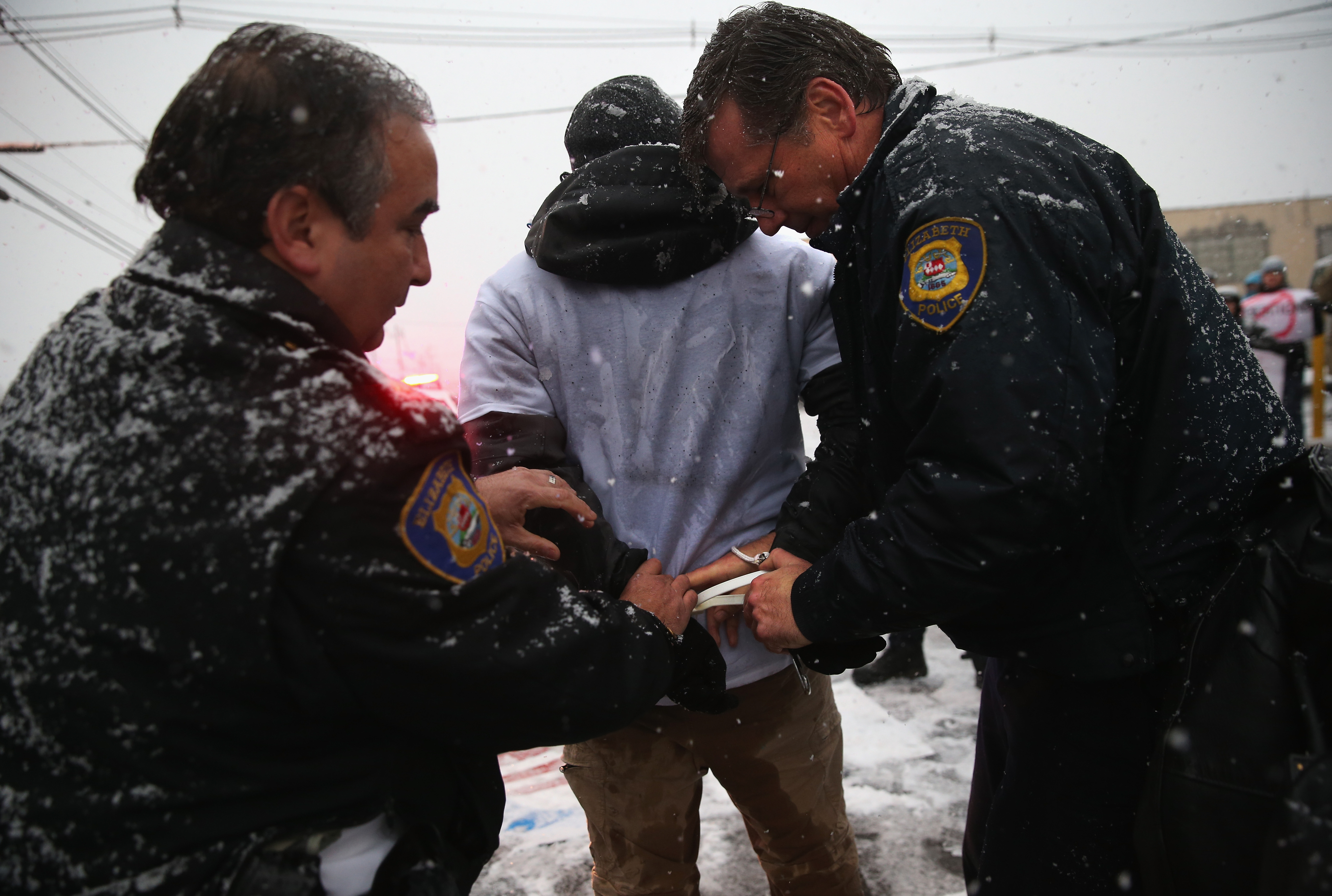 ELIZABETH, NJ - DECEMBER 10: Police arrest protesters blocking the entrance of an immigrant detention center on December 10, 2013 in Elizabeth, New Jersey. A coalition of immigrant advocacy groups marked international Human Rights Day, staging the civil disobedience action at the Elizabeth Detention Center, and eight protesters were arrested. The event was designed to draw attention to the continued mass deportations of undocumented immigrants by the U.S. Immigration and Customs Enforcement (ICE), as well as Congress' inability to pass immigration reform. The Obama administration is on track to have removed 2 million immigrants from the United States, the most of any presidential administration. (Photo by John Moore/Getty Images)