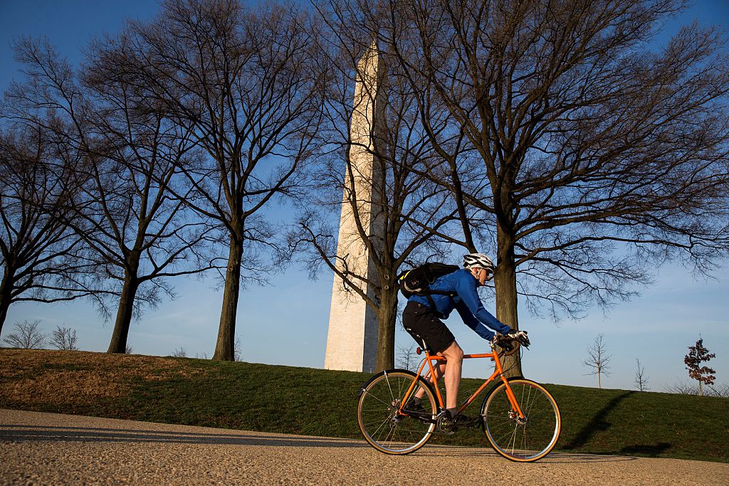 A man rides his bike near the base of the Washington Monument during his morning commute in Washington, USA on March 16, 2016. (Credit: Samuel Corum/Anadolu Agency/Getty Images)