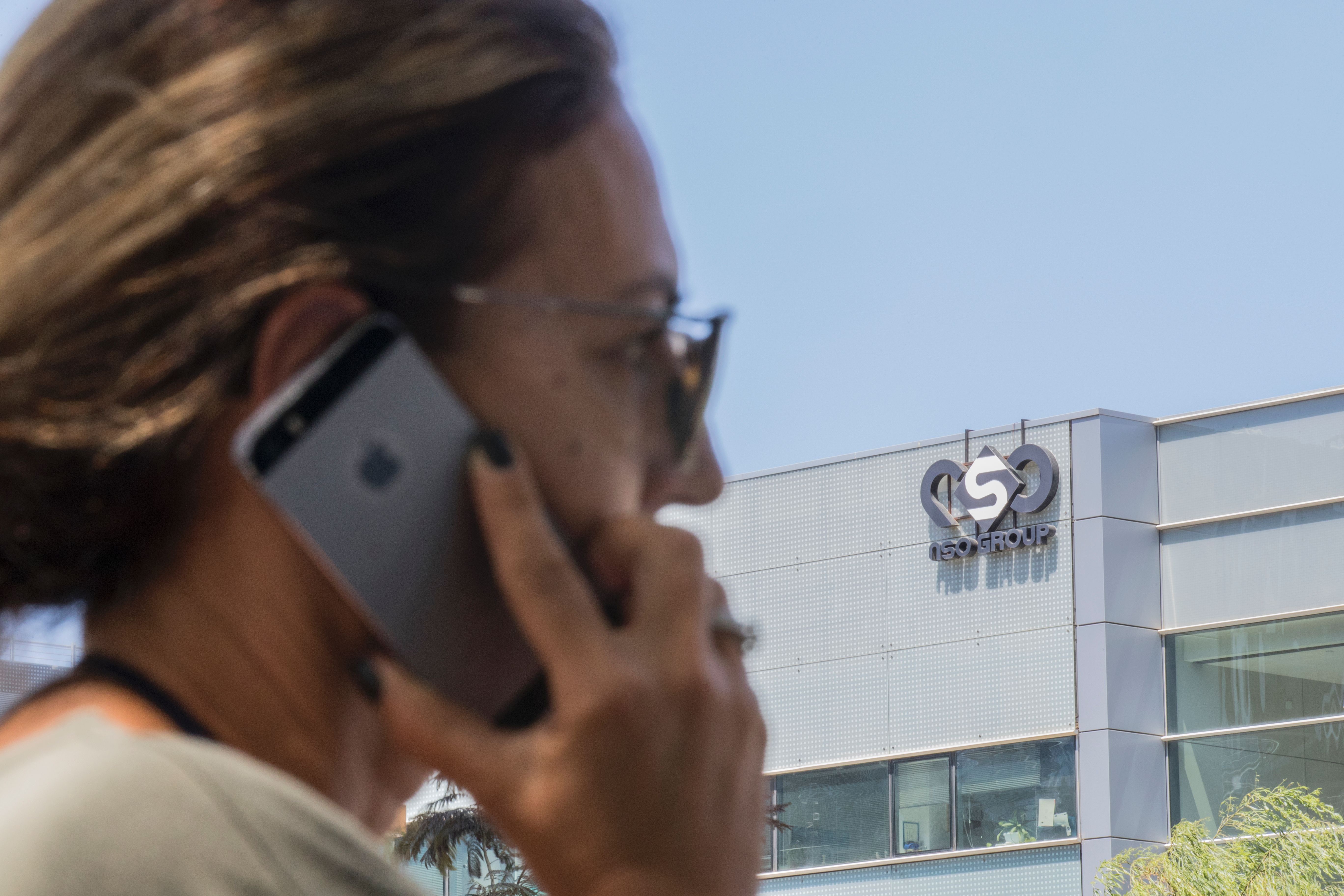 An Israeli woman uses her pone in front of the building housing the Israeli NSO Group in Herzliya, near Tel Aviv. CREDIT:
Jack Guez/AFP/Getty Images.