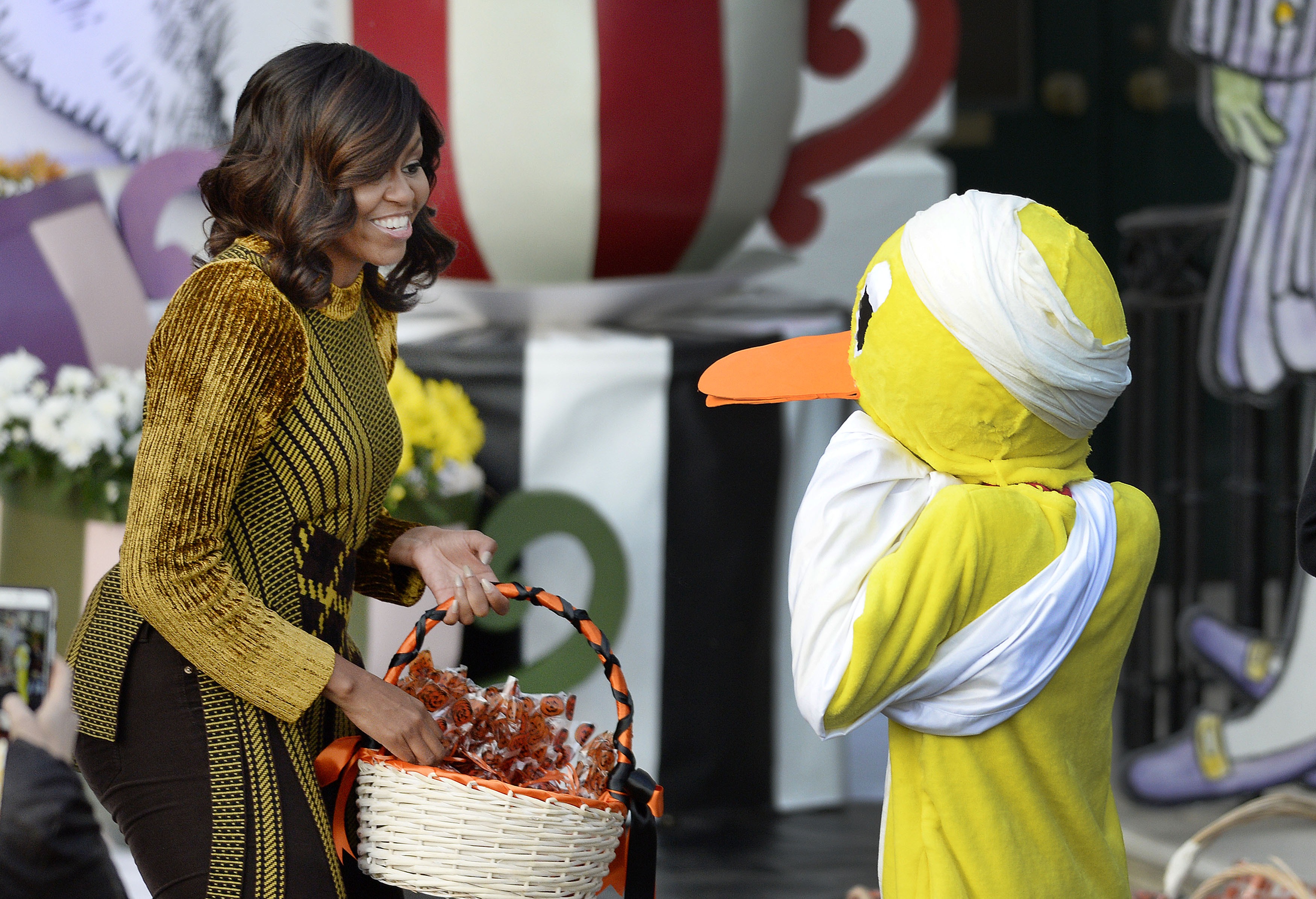 WASHINGTON, DC - OCTOBER 31: First lady Michelle Obama hands out treats to a child dressed as a 'lame duck' during a Halloween event at the South Lawn of the White House October 31, 2016 in Washington, DC. (Photo by Olivier Douliery-Pool/Getty Images)