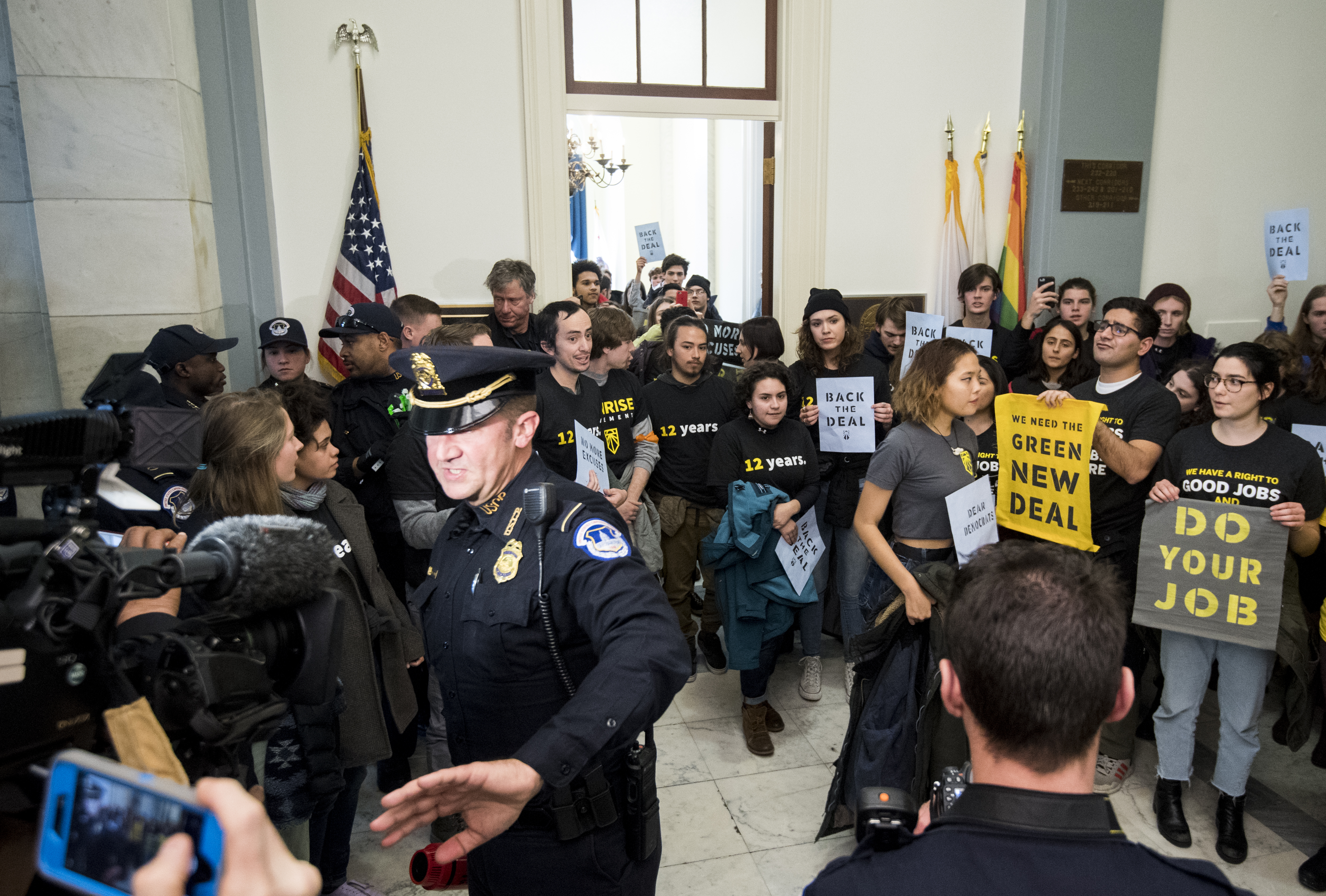 Climate change activists with the Sunrise Movement urge House Minority Leader Nancy Pelosi to support panel on Green New Deal in the Cannon House Office Building on December 10, 2018. CREDIT: Bill Clark/CQ Roll Call