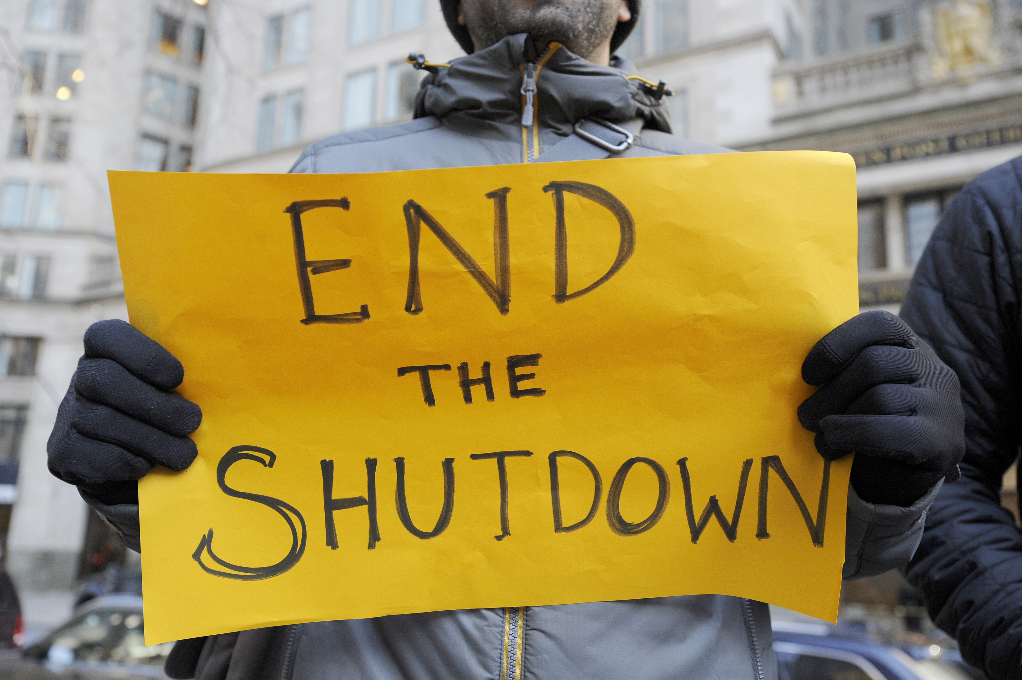 Protesters hold signs during a rally and protest by government workers and concerned citizens against the government shutdown on Friday, January 11, 2019 at Post Office Square near the Federal building, headquarters for the EPA and IRS in Boston. - The rally was organized by The American Federation of Government Employees (AFGE). New England has 516 EPA employees that is now down to a staff of 22. (Photo by Joseph PREZIOSO / AFP) (Photo credit should read JOSEPH PREZIOSO/AFP/Getty Images)