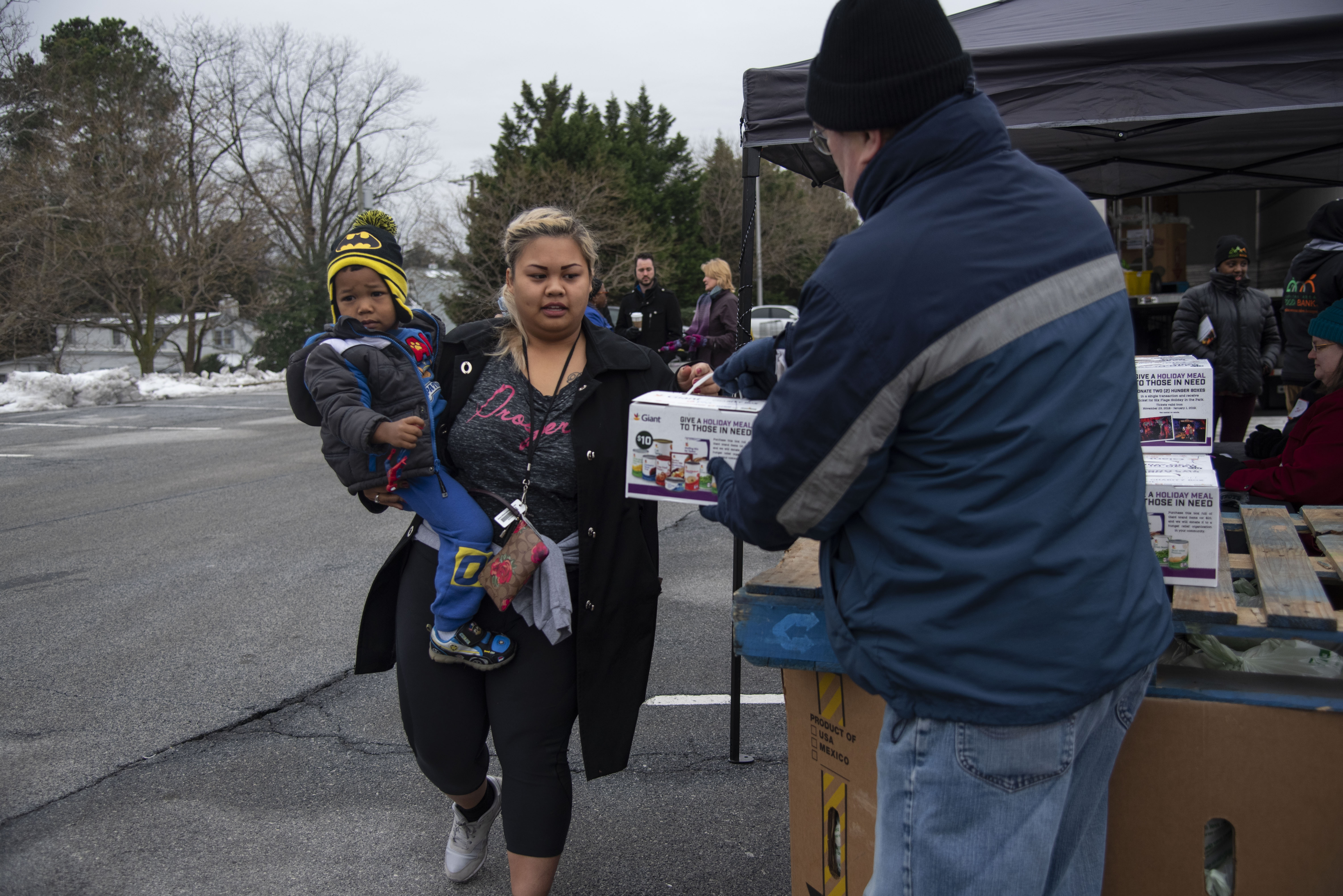 ALEXANDRIA, VA - JANUARY 19: The Capital Area Food Bank passed out canned goods and produce to federal workers as the government shutdown continues outside a Giant grocery store in Alexandria, Virginia on January 19, 2019. Here, Alexis Ing, who works for the State Department, and her son Robert get their food. (Photo by Calla Kessler/The Washington Post via Getty Images)