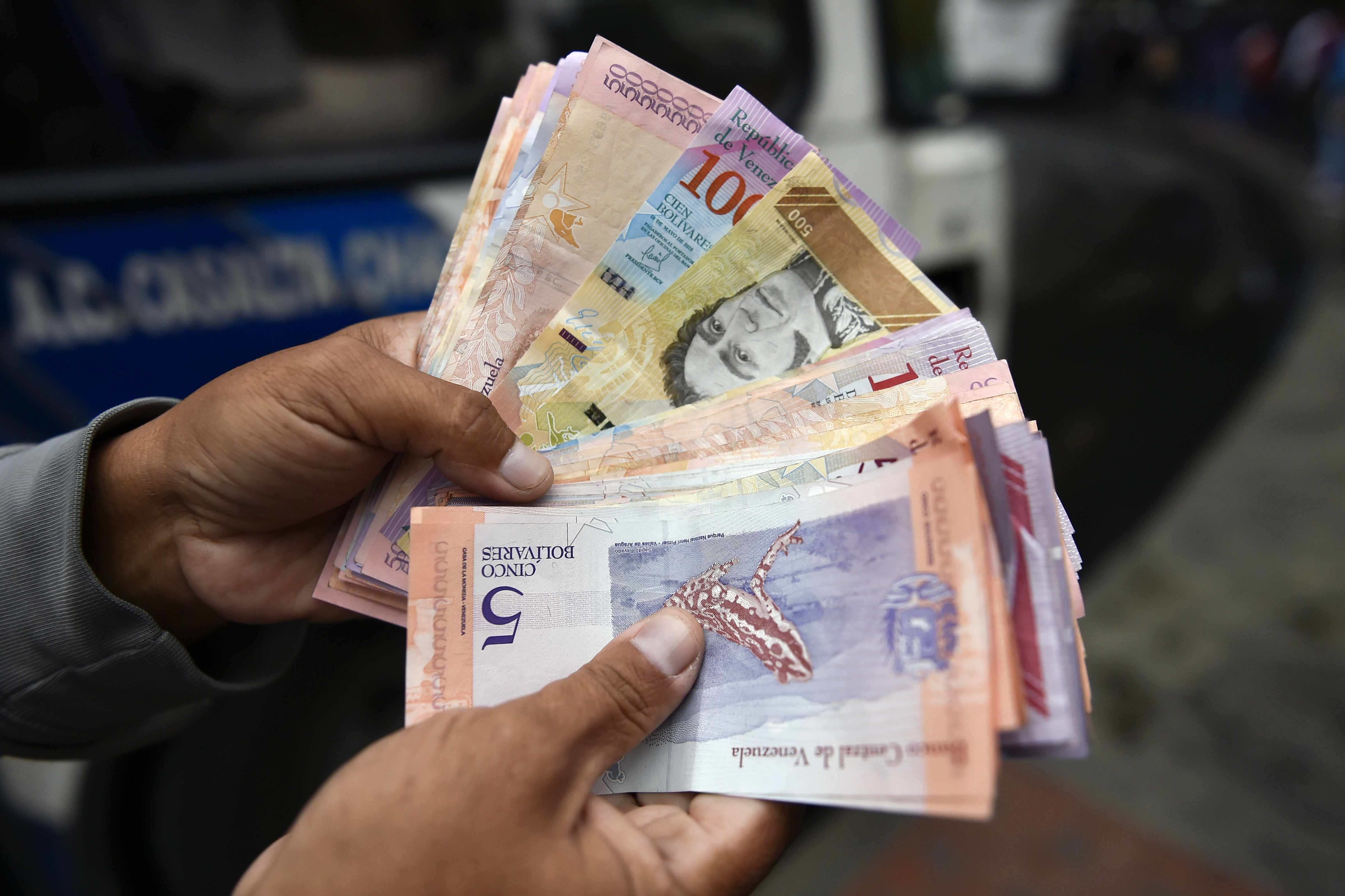 A man counts Bolivar bills in a street of Caracas on January 29, 2019. - Venezuela devalued its currency by almost 35 percent on Monday to bring it into line with the exchange rate of the dollar on the black market. CREDIT: Luid Robayo/AFP/ Getty Images.