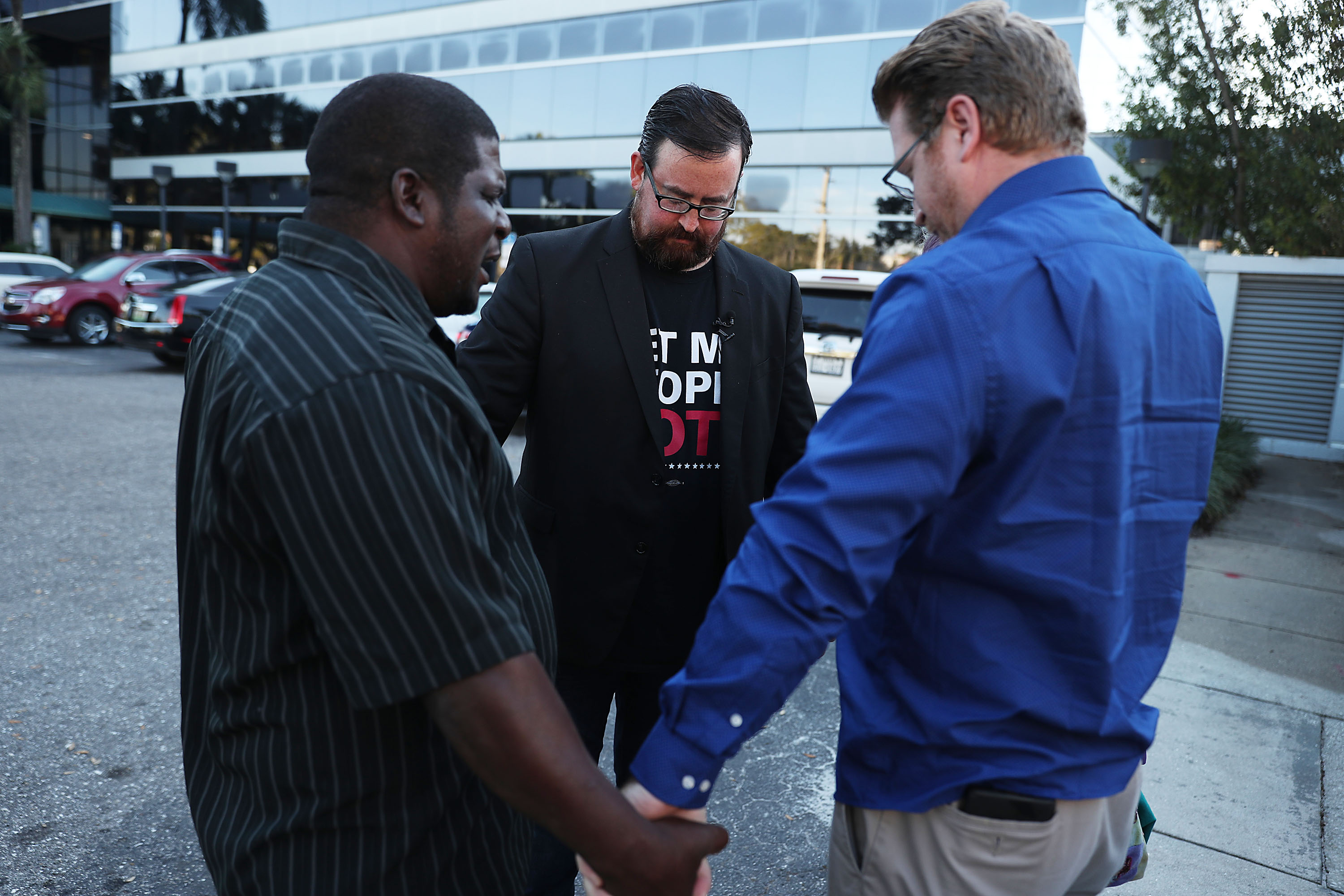 Permon Thomas (L) prays with Neil Volz (C) and Lance Wissinger (R). CREDIT: Joe Raedle/Getty Images