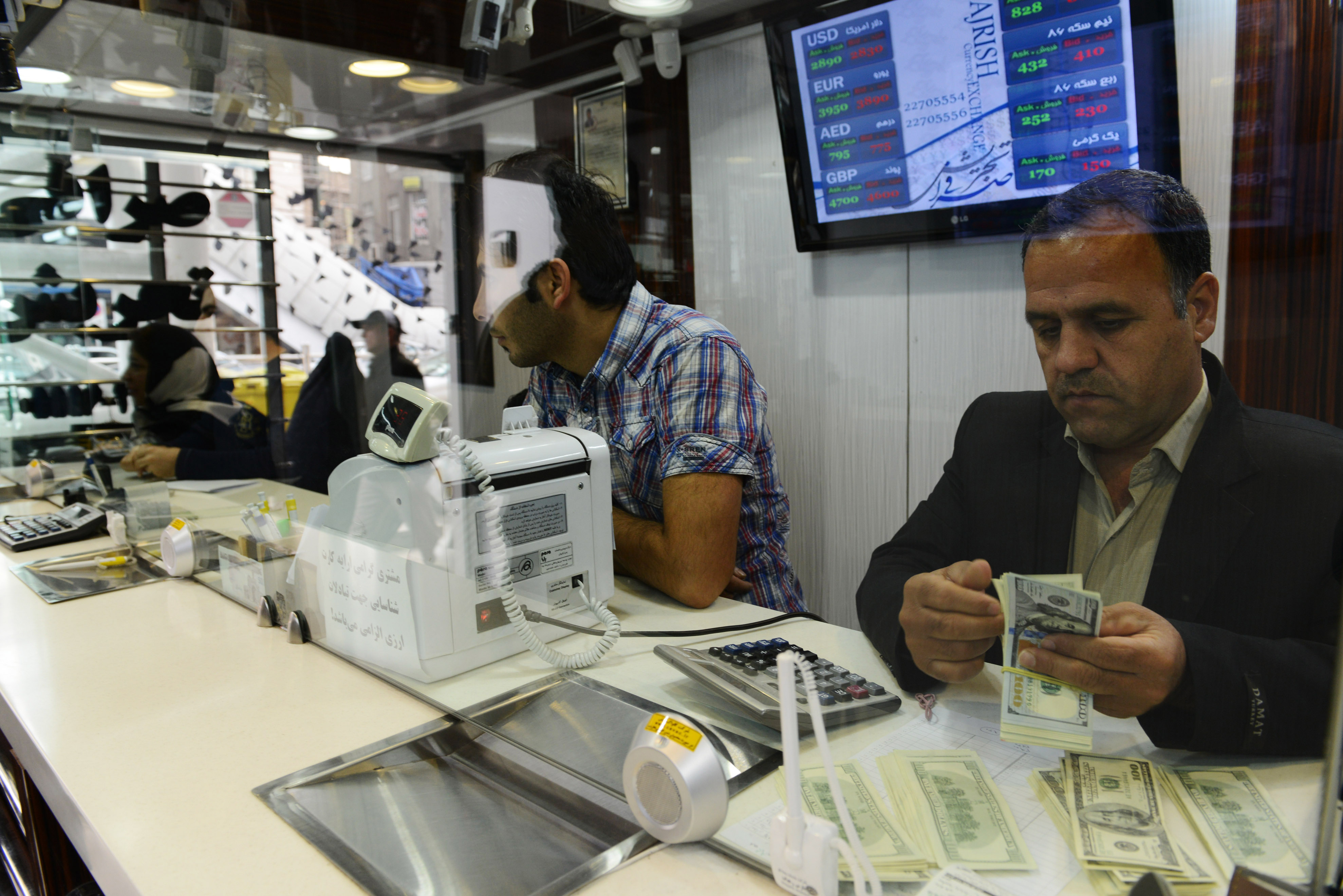 A man counts US Dollar banknotes in an official exchange house. CREDIT: Kaveh Kazemi/Getty Images.
