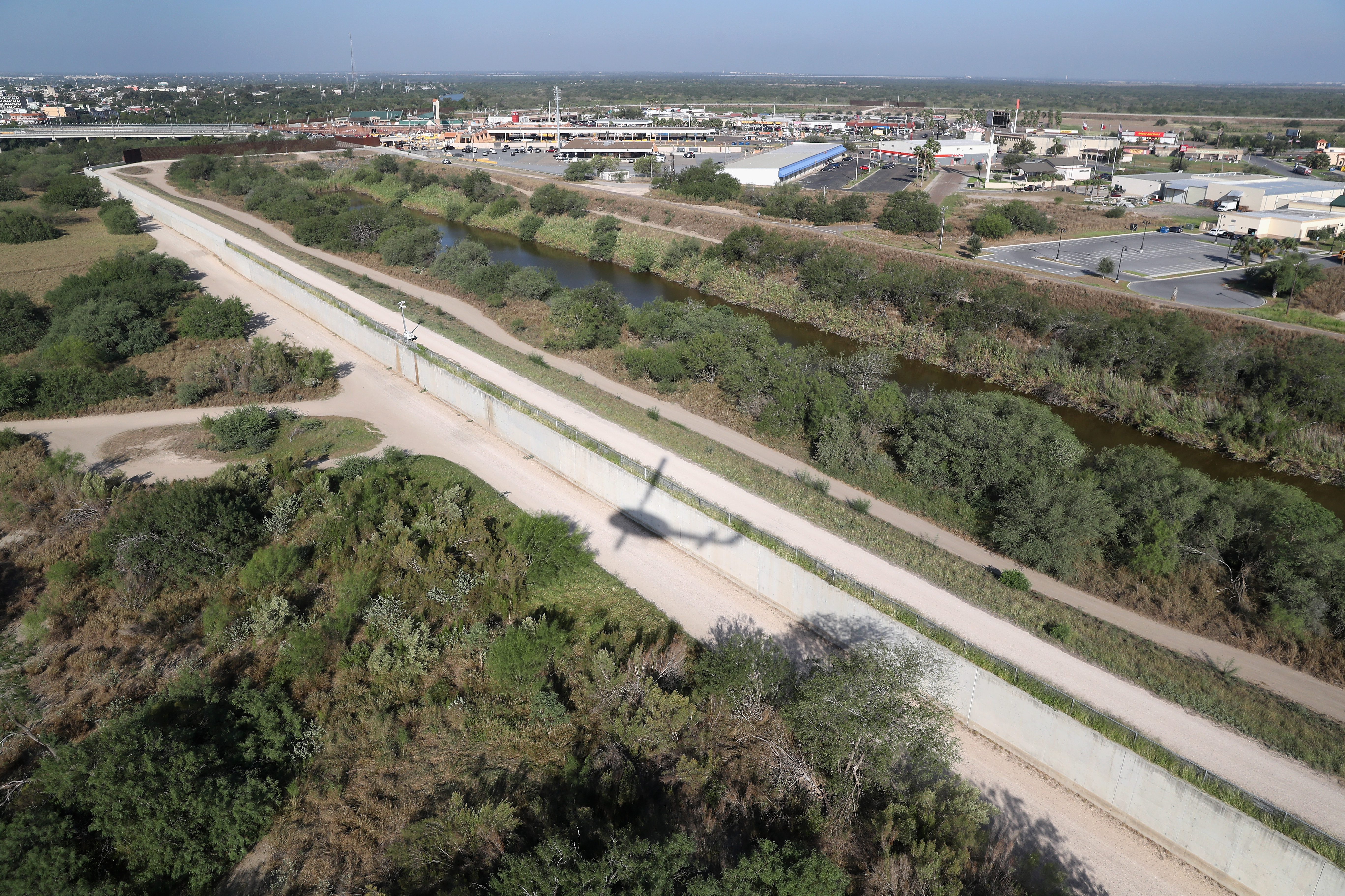 A U.S. Customs and Border Protection helicopter flies over a border fence in the Rio Grande Valley, where bulldozers are supposed to start rolling in February on new fence projects. CREDIT: John Moore/Getty Images