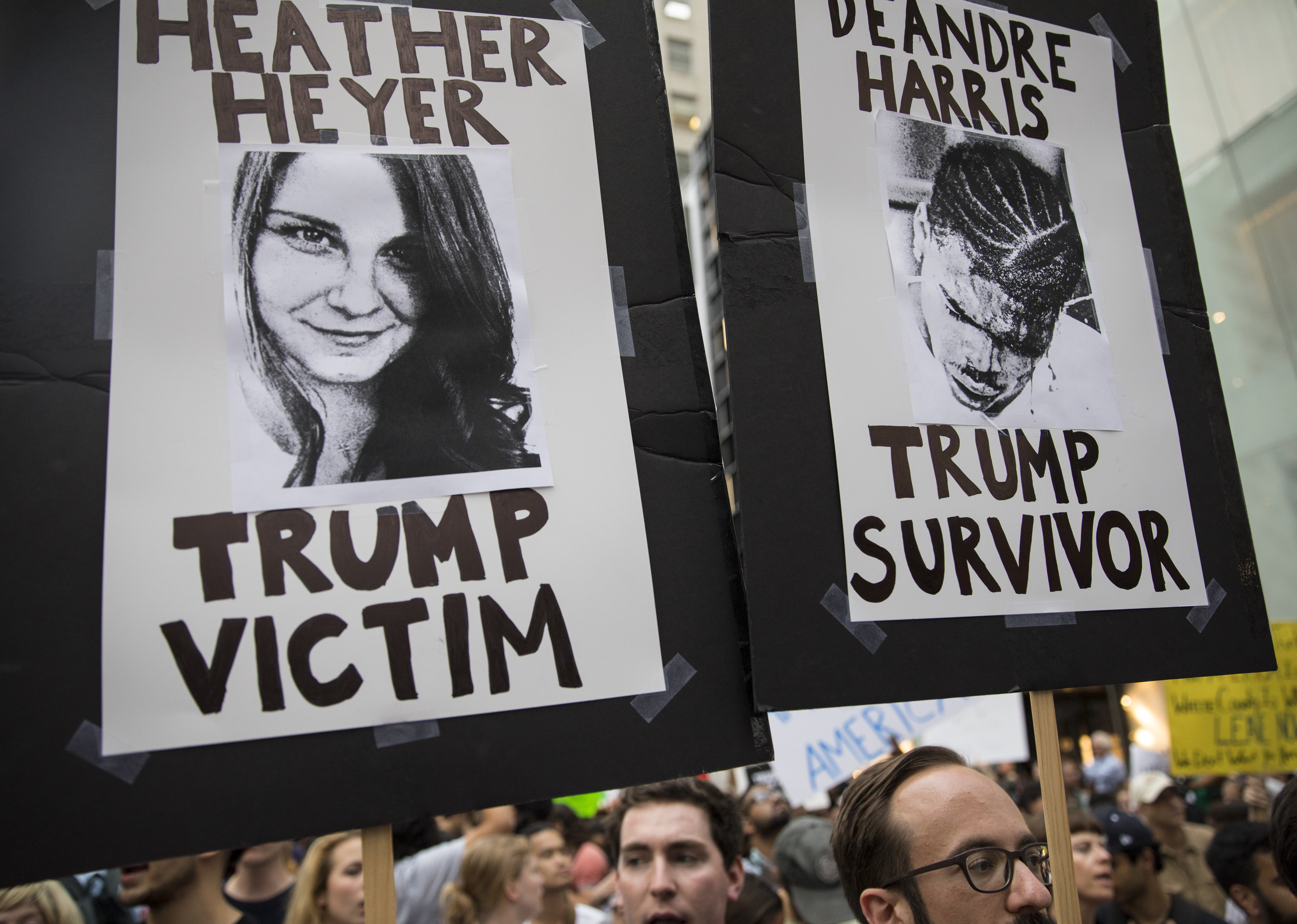 Protesters carry posters of Heather Heyer, who was murdered by a white supremacist in Charlottesville in 2017, and Deandre Harris , who was badly beaten by four of them the same day. CREDIT: Robert Nickelsberg/Getty Images