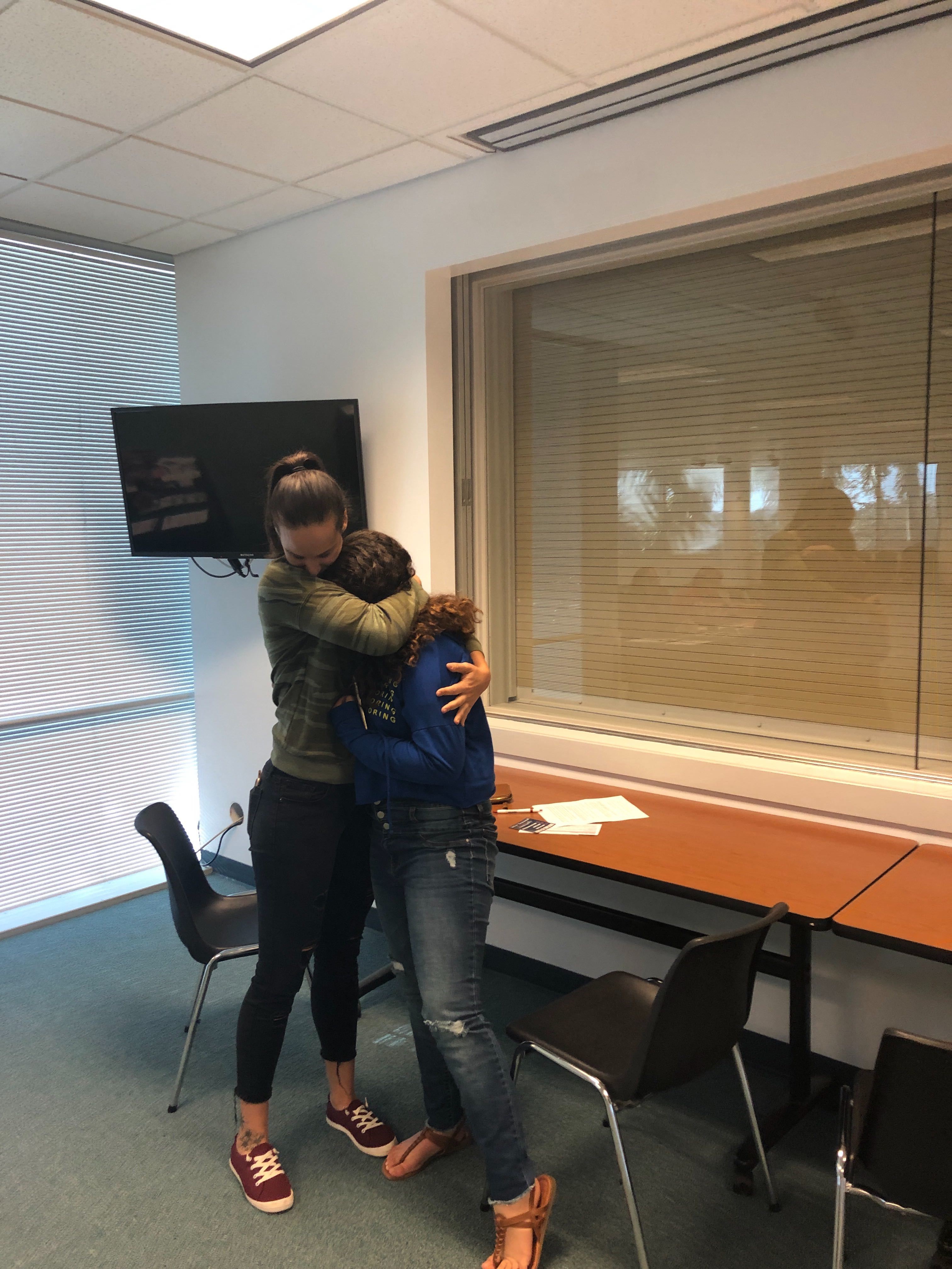 Erica Racz hugs her daughter after registering to vote. (PHOTO CREDIT: Addy Baird)