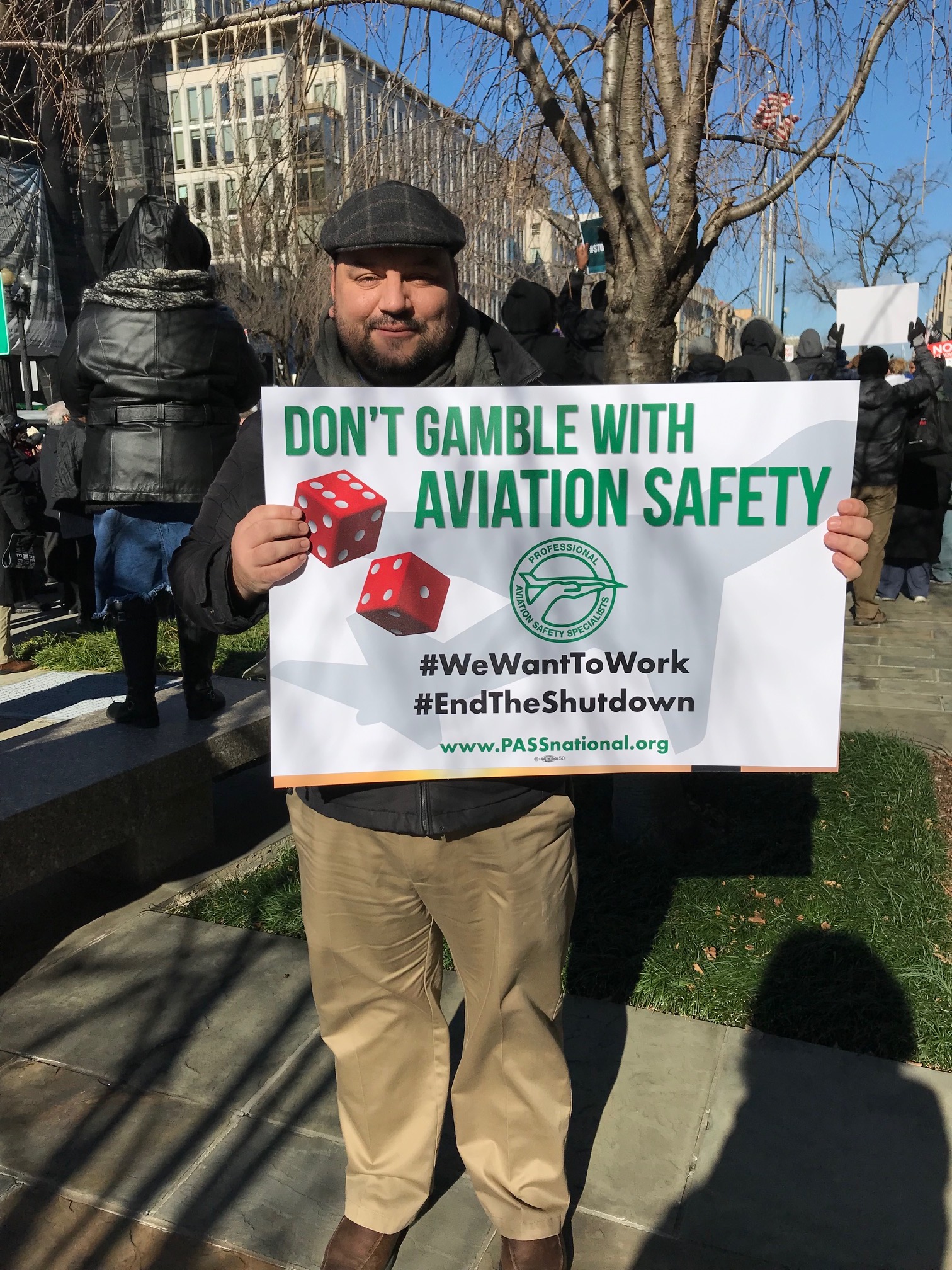 Ben Struckus holds his sign at the rally for federal workers on Thursday. CREDIT: Casey Quinlan