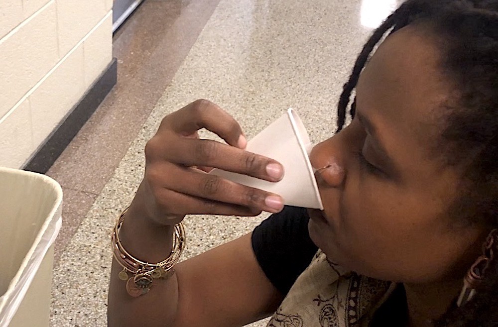 Southeastern math teacher Kiarra Ambrose quenches her thirst at a water cooler. CREDIT: Sierra Searcy