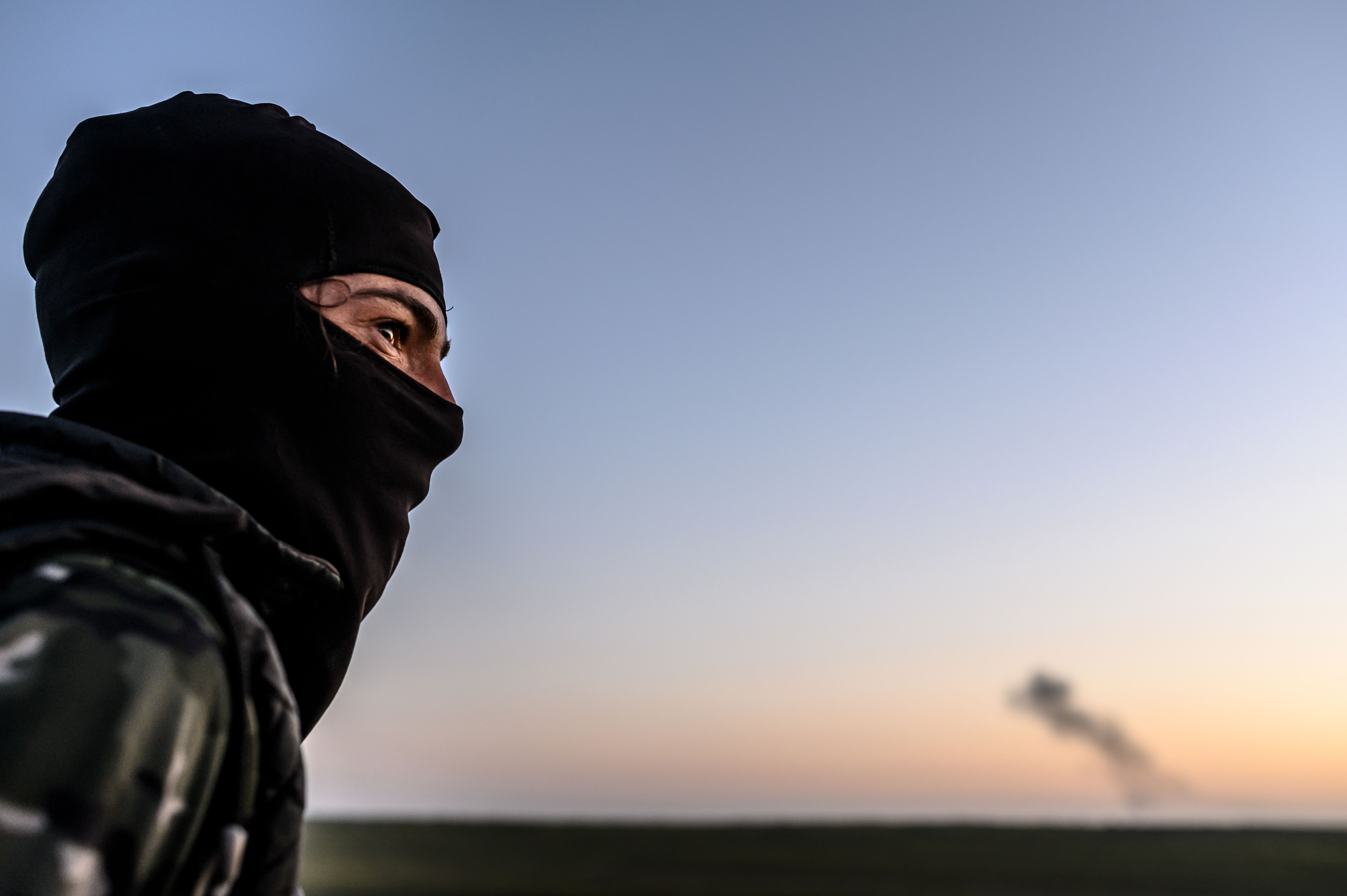 A Syrian Democratic Forces fighter looks towards the embattled village of Baghouz in Syria's northern Deir Ezzor province on February 19, 2019. CREDIT: Bulent Kolic/AFP/Getty Images.