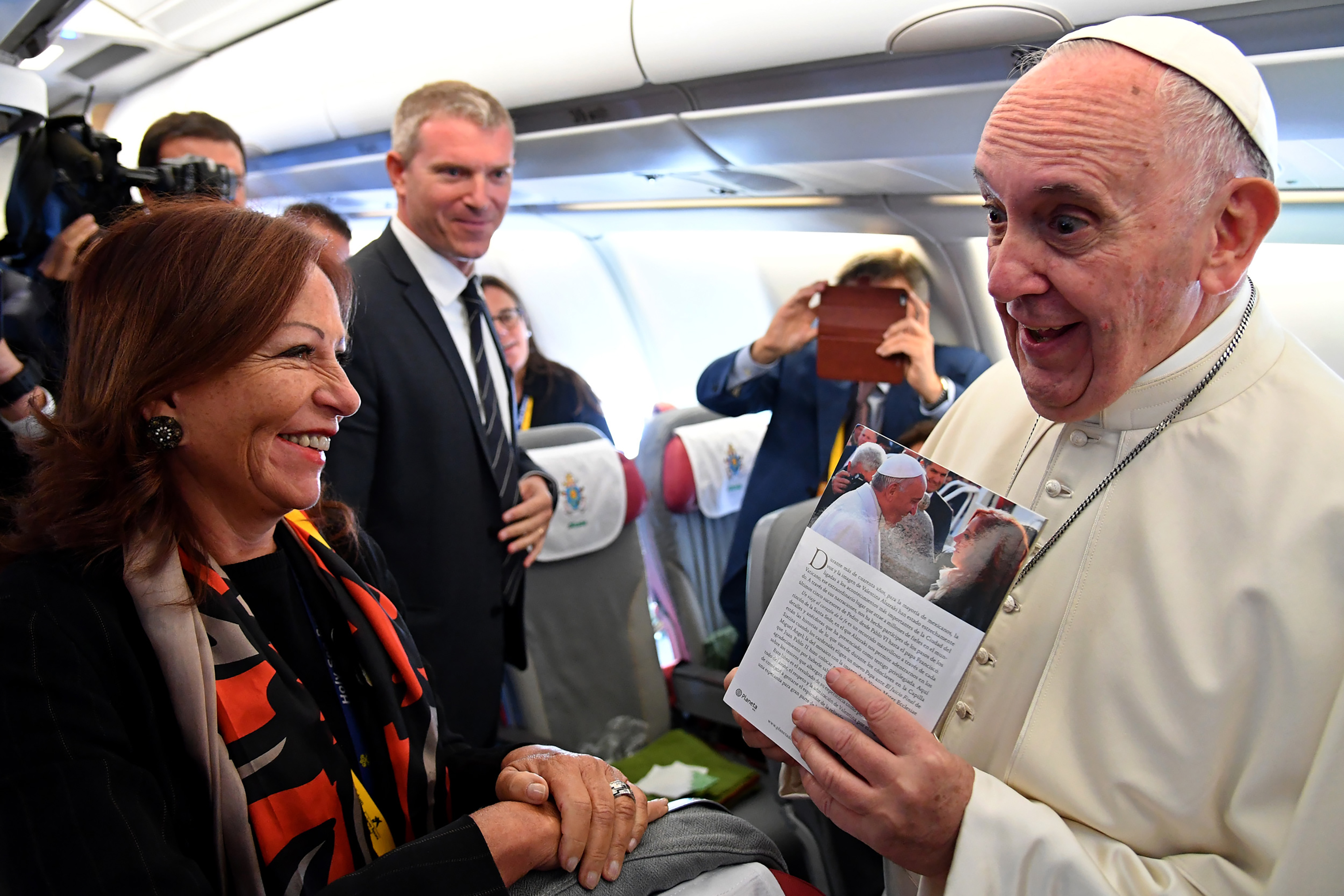 Pope Francis (R) holds a book from journalist Maria Valentina Alazraki (L) as he speaks with journalists on an aircraft on September 6, 2017, as he travels to Colombia. (ALBERTO PIZZOLI/AFP/Getty Images)