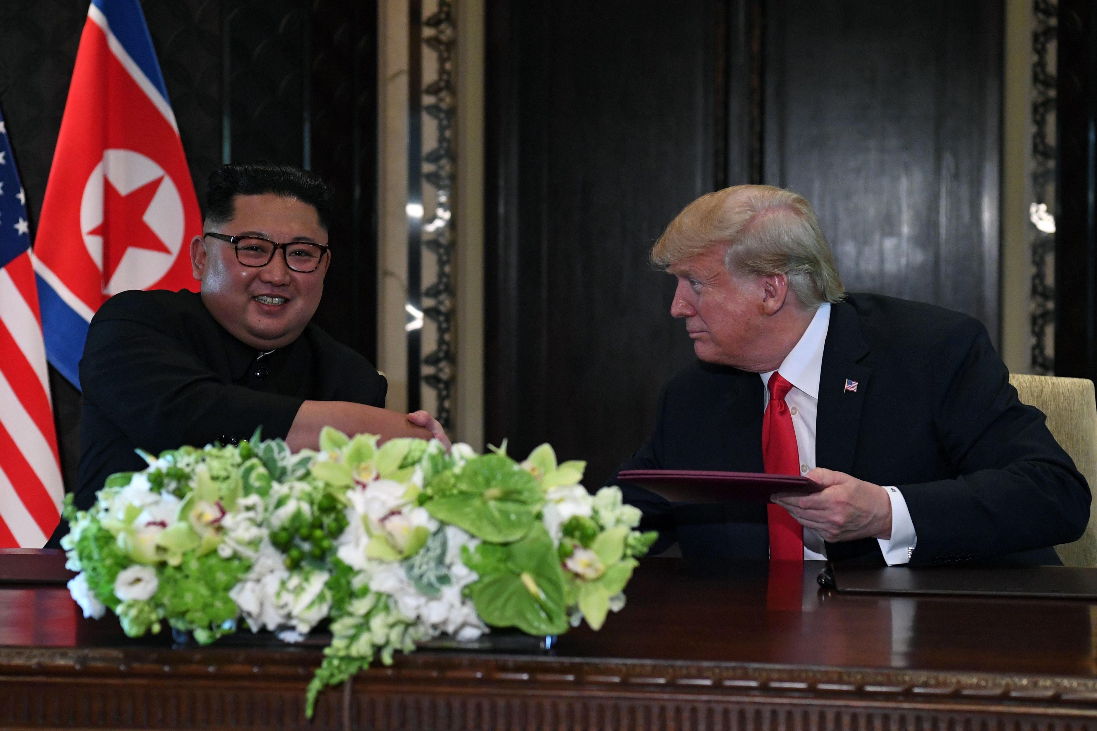 North Korea's leader Kim Jong Un (L) shakes hands with President Donald Trump at a signing ceremony during their historic U.S.-North Korea summit in Singapore on June 12, 2018. CREDIT: SAUL LOEB/AFP/Getty Images