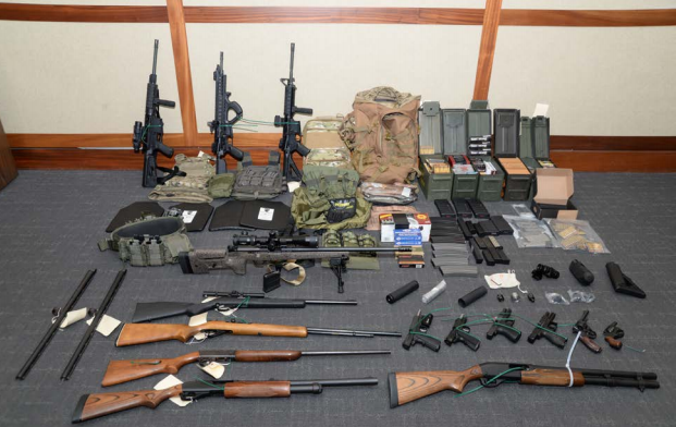The arsenal of weapons law enforcement discovered at Chris Hasson's home. (Credit: Screenshot)