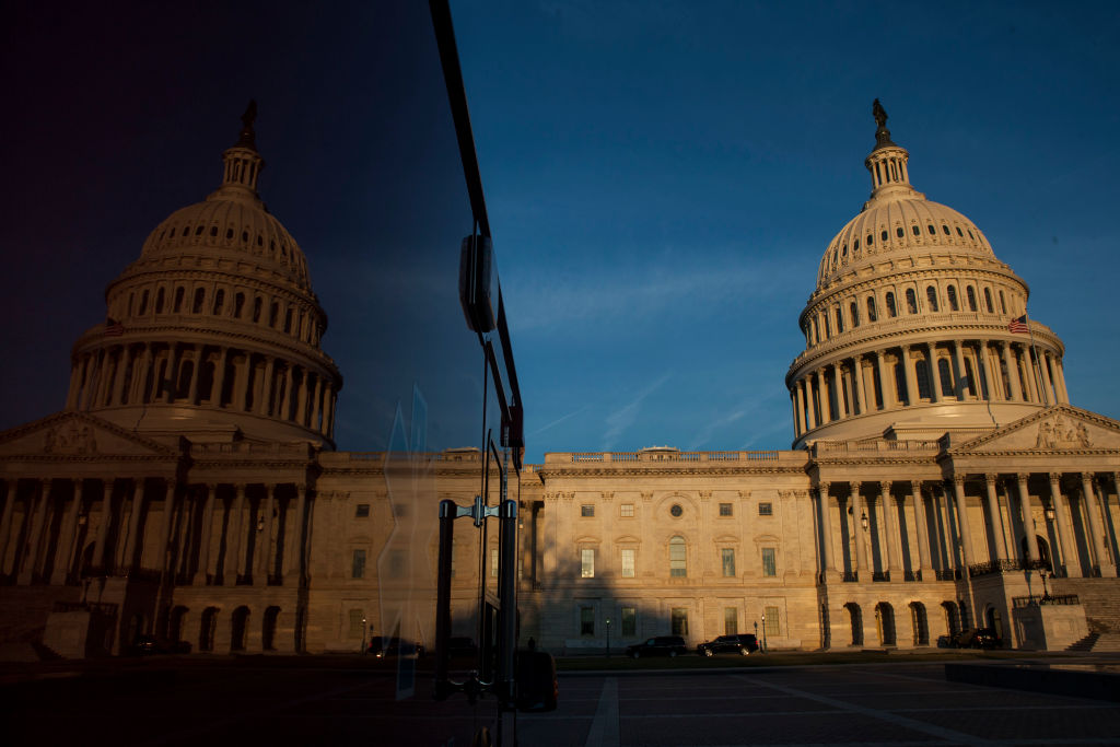 The United States Capitol Building reflects on a truck as the sunrises in Washington, D.C. (Credit: Zach Gibson/Getty Images)