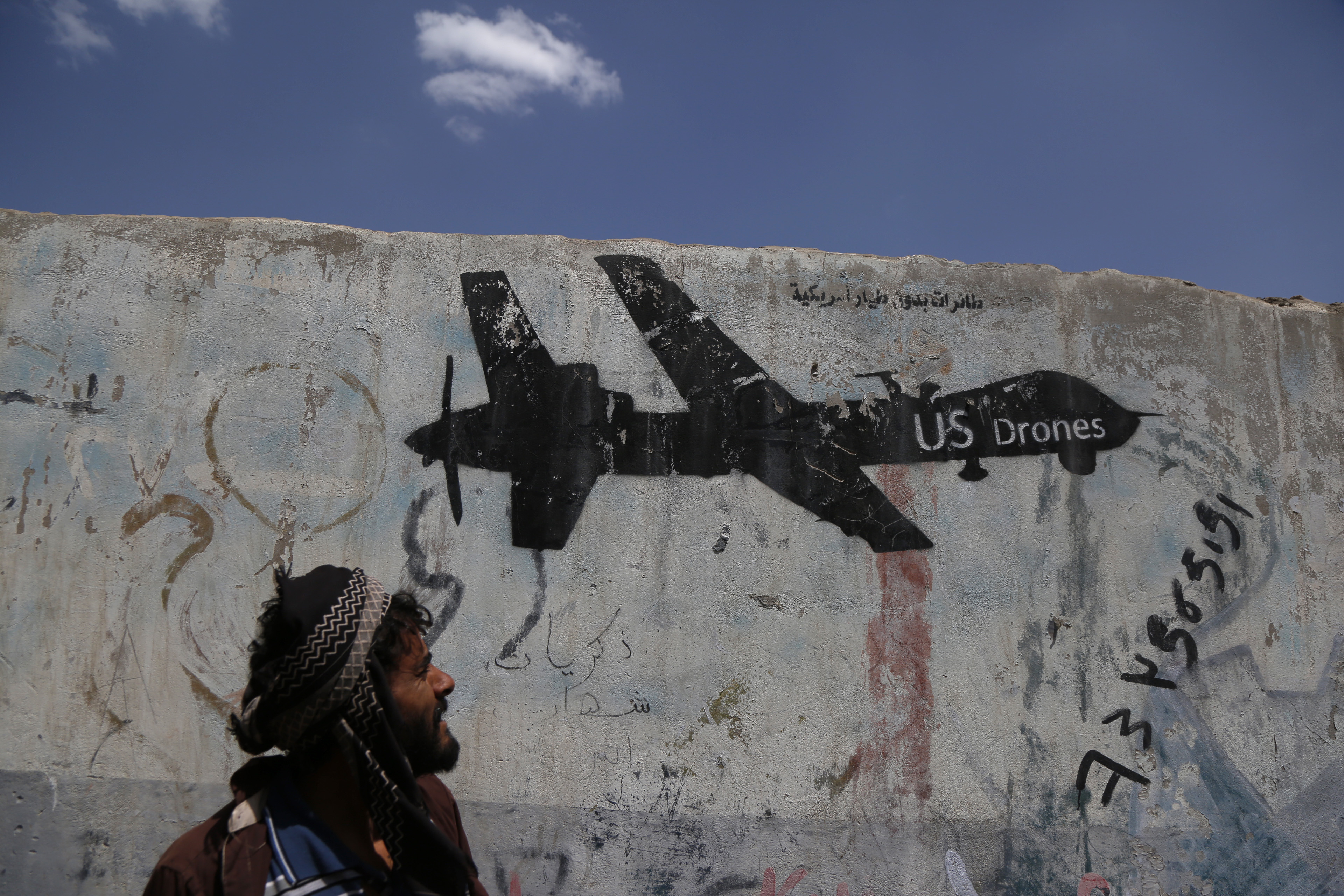 A Yemeni man looks at graffiti protesting against US drone strikes on September 19, 2018 in Sana'a, Yemen. CREDIT: Mohammed Hamoud/Getty Images.
