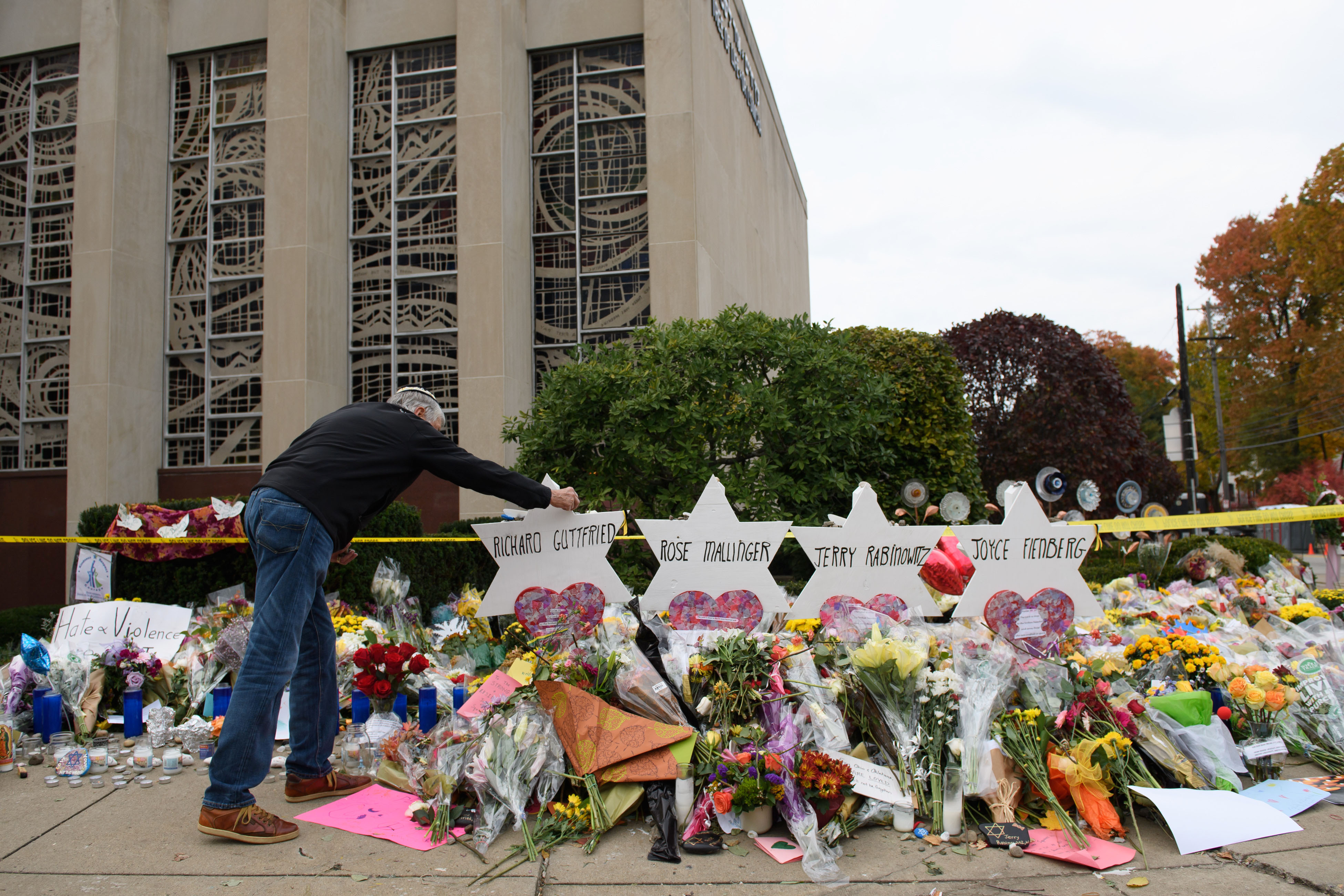 A mourner places flowers outside the Tree of Life synagogue in Pittsburgh, PA, where a far-right extremist killed 11 worshipers last October. (Photo credit: Jeff Swensen/Getty Images)