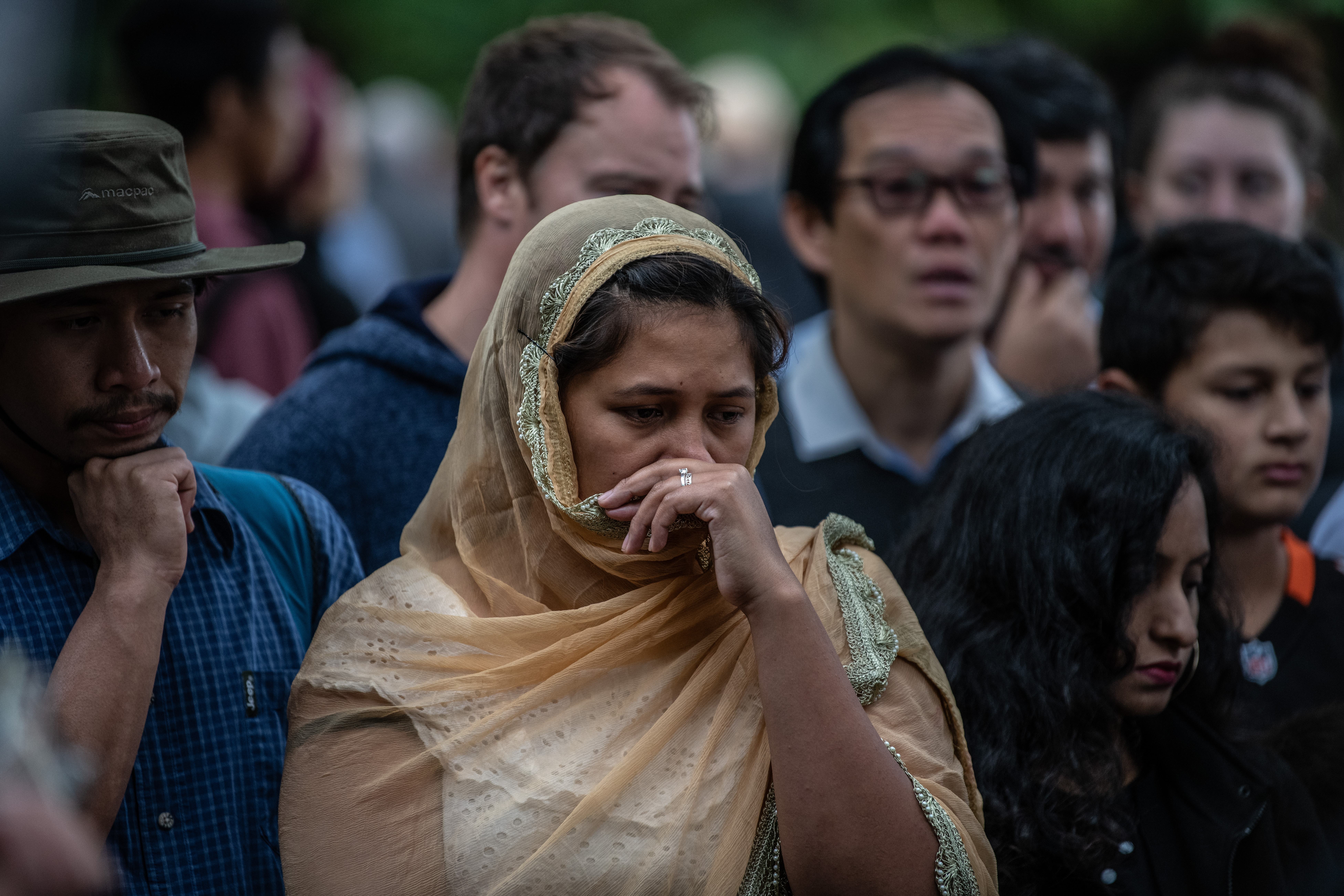 A woman looks on as people gather near Al Noor mosque on March 17, 2019, in Christchurch, New Zealand. (Photo Credit: Carl Court/Getty Images)