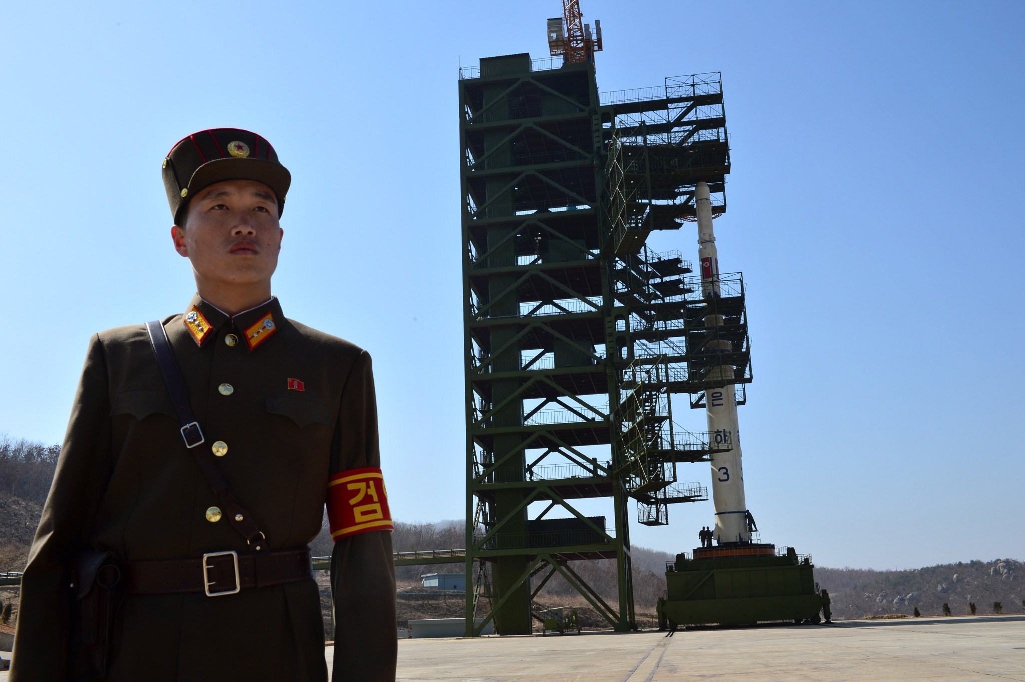 A North Korean soldier stands guard in front of the Unha-3 rocket at the Sohae Satellite Launch Station in Tongchang-Ri on April 8, 2012. CREDIT: Pedro Ugarte/AFP/Getty Images.
