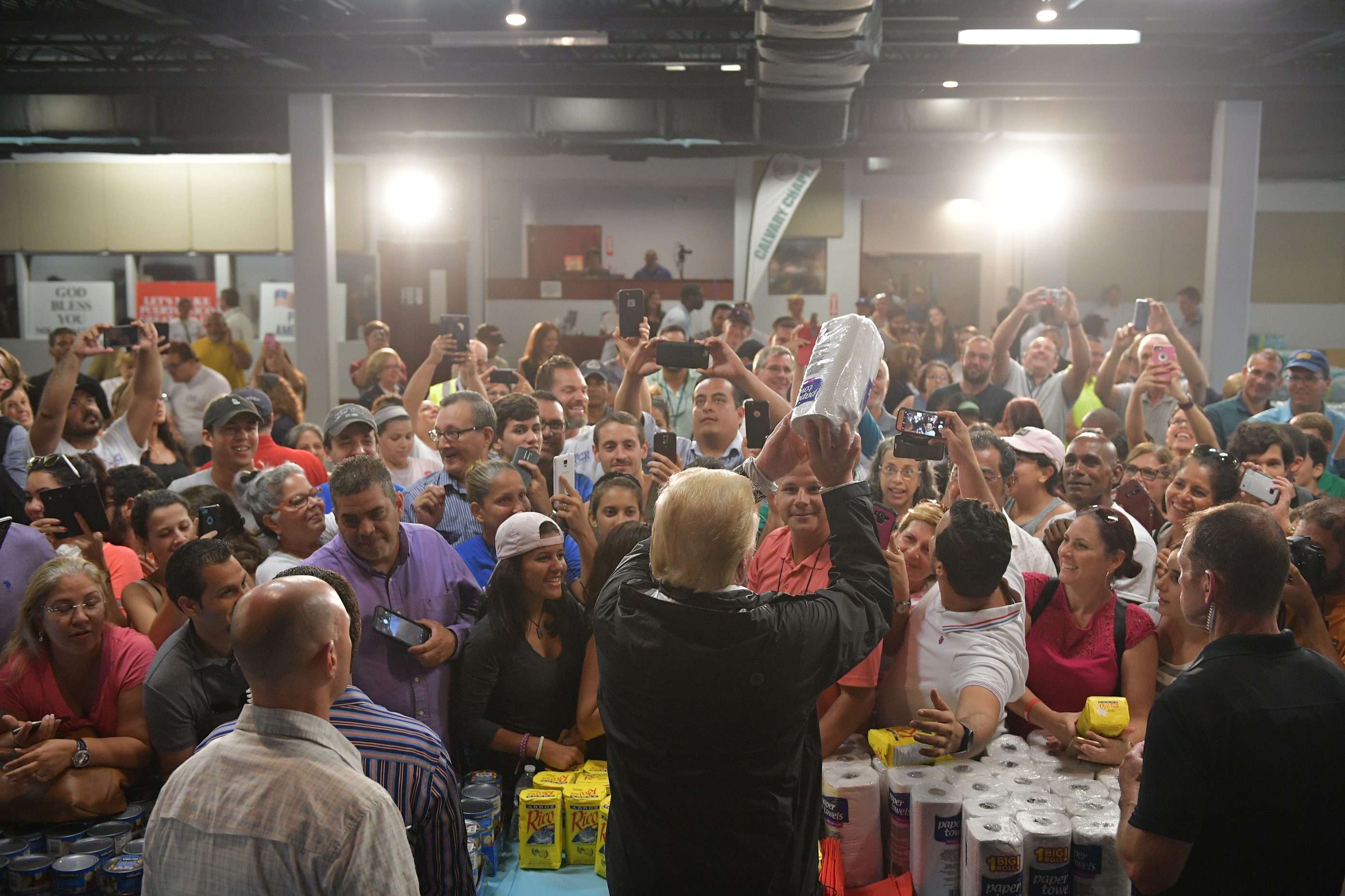 US President Donald Trump throws a paper towel roll as he visits the Cavalry Chapel in Guaynabo, Puerto Rico on October 3, 2017. (Credit: MANDEL NGAN/AFP/Getty Images)