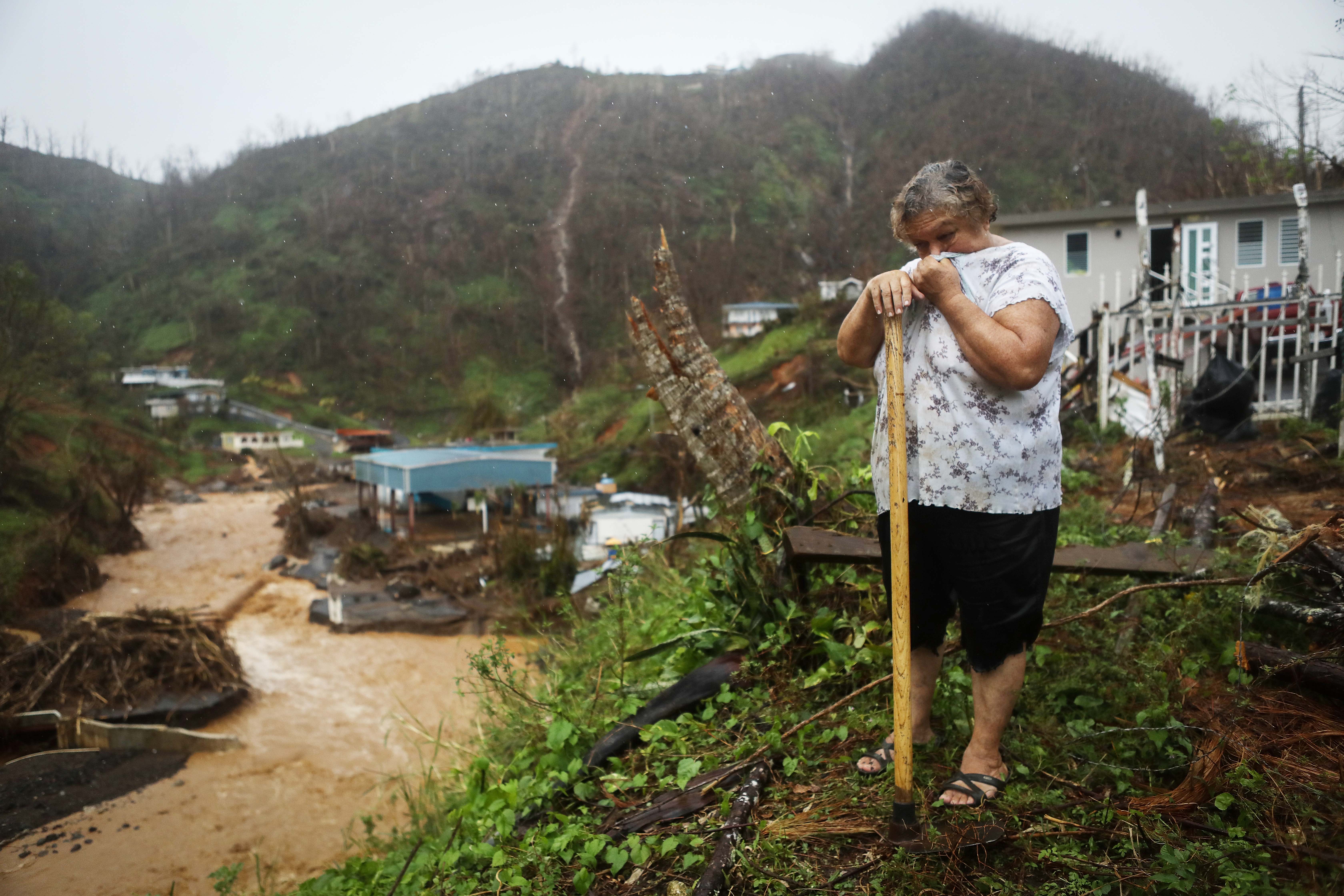 Carmen Cintron Torres takes a break from cleaning debris in front of her home more than two weeks after Hurricane Maria hit the island, on October 7, 2017 in Barranquitas, Puerto Rico. CREDIT: Mario Tama/Getty Images