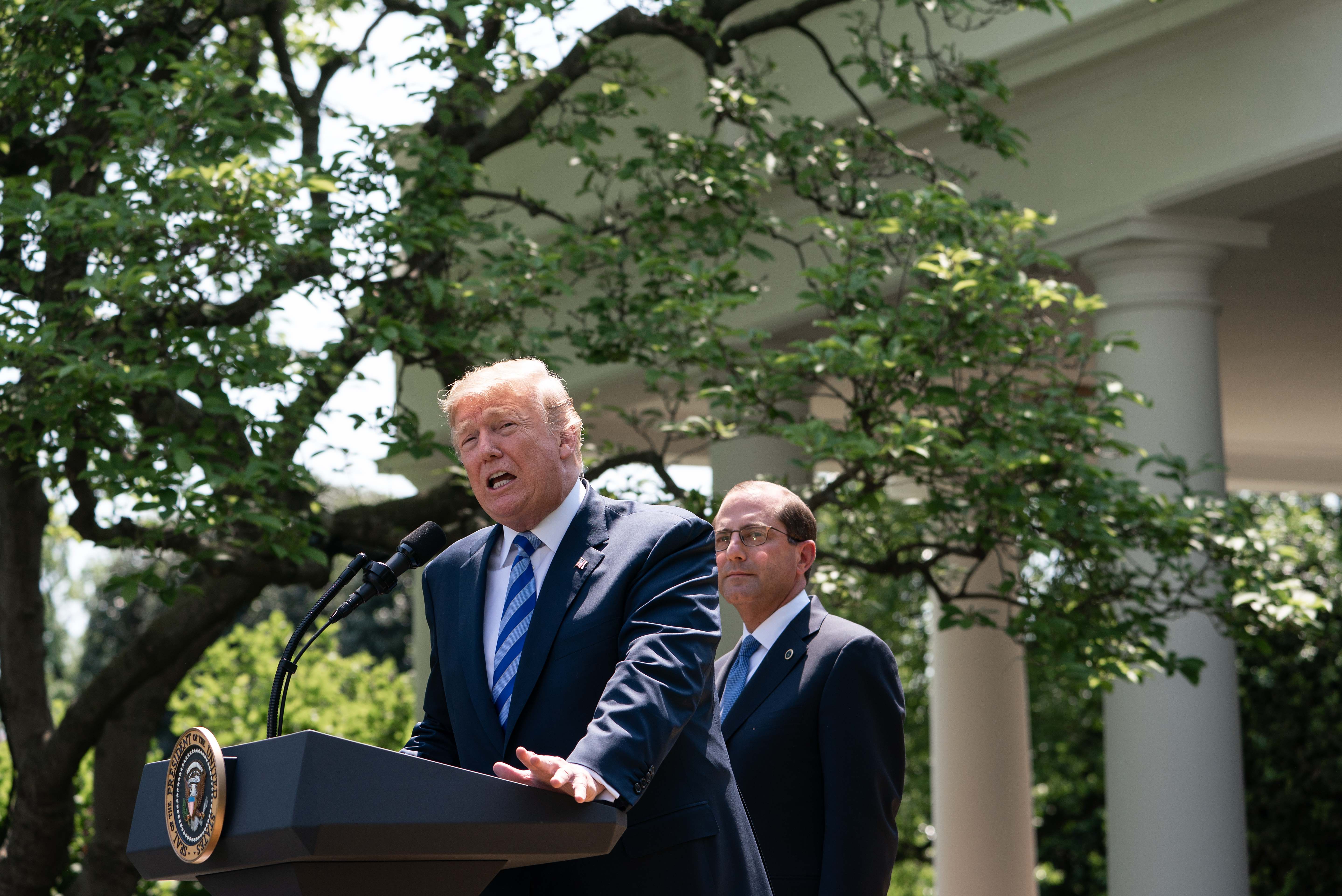 US President Donald Trump delivers remarks with Health and Human Services Secretary Alex Azar (R) on reducing drug costs in the Rose Garden at the White House in Washington, DC, on May 11, 2018. (Photo by NICHOLAS KAMM / AFP) (Photo credit should read NICHOLAS KAMM/AFP/Getty Images)