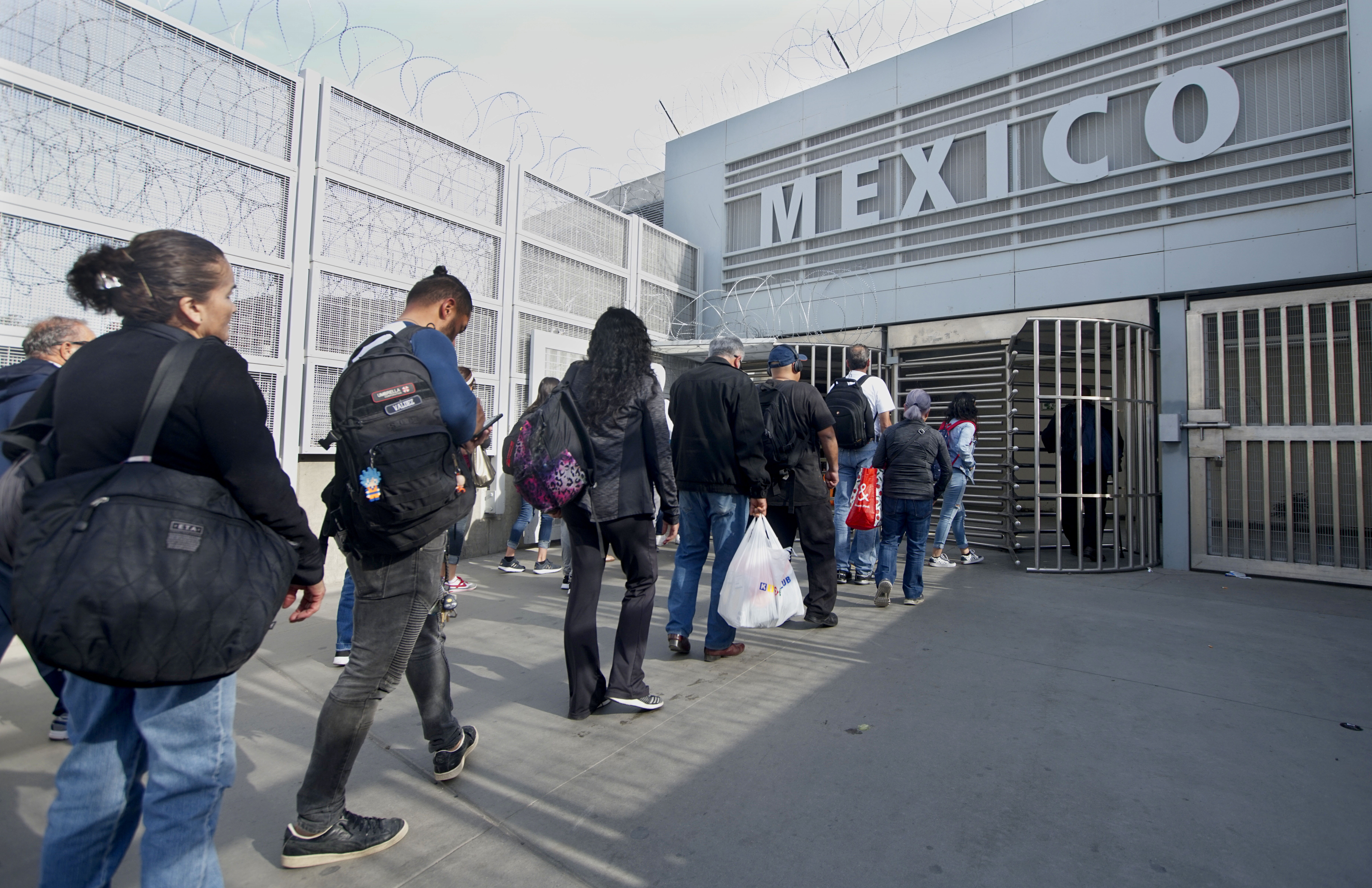Pedestrians walk towards the U.S.-Mexico border at the San Ysidro Port of Entry on March 29, 2019 in San Diego, California. President Donald Trump has threatened to close the United States border if Mexico does not stem the flow of illegal migrants trying to cross. CREDIT: Sandy Huffaker/Getty Images.