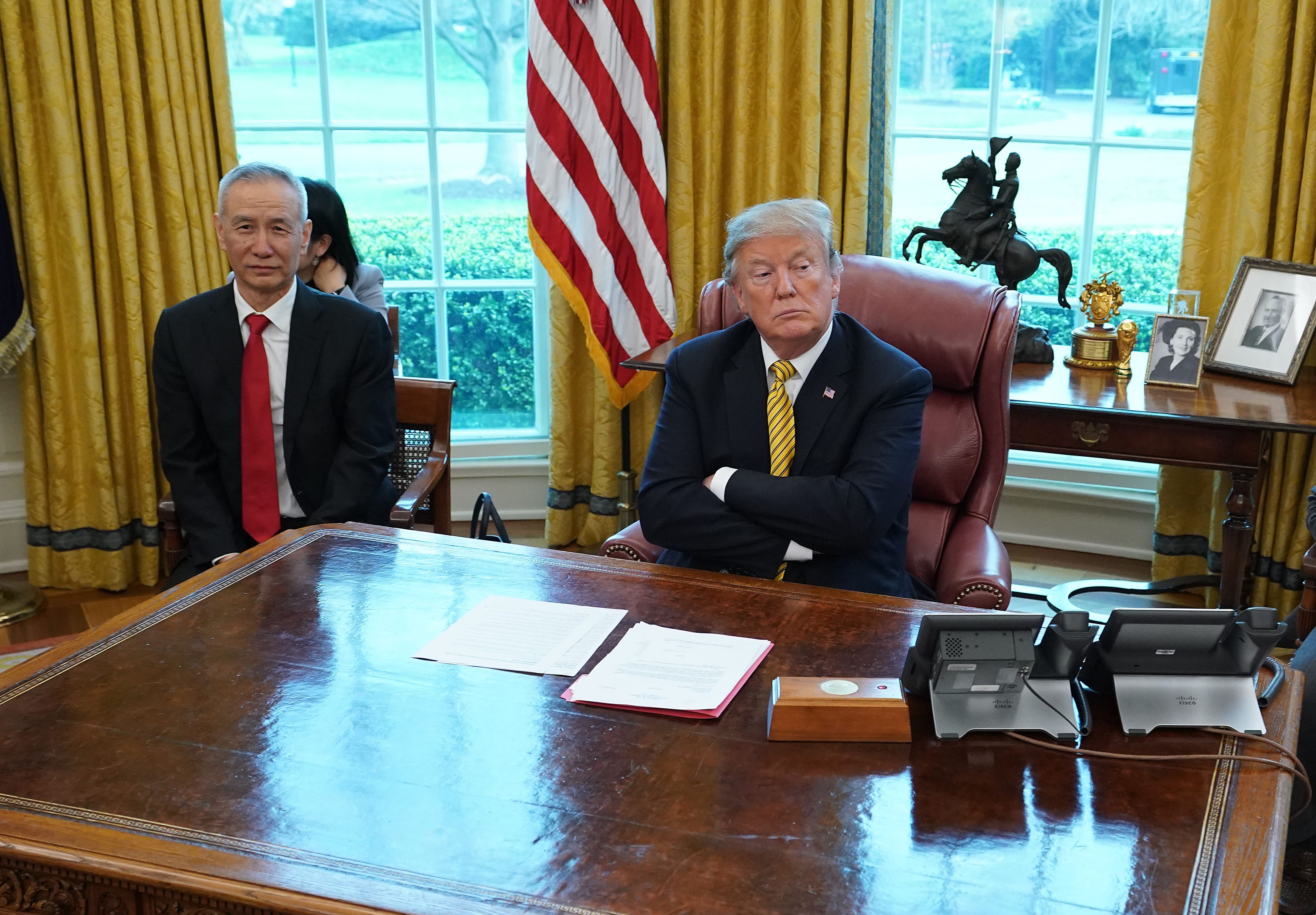 President Donald Trump and Chinese Vice Premier Liu He wait for journalists to leave the the Oval Office before beginning their meeting at the White House April 04, 2019 in Washington, D.C. (PHOTO CREDIT: Chip Somodevilla/Getty Images)