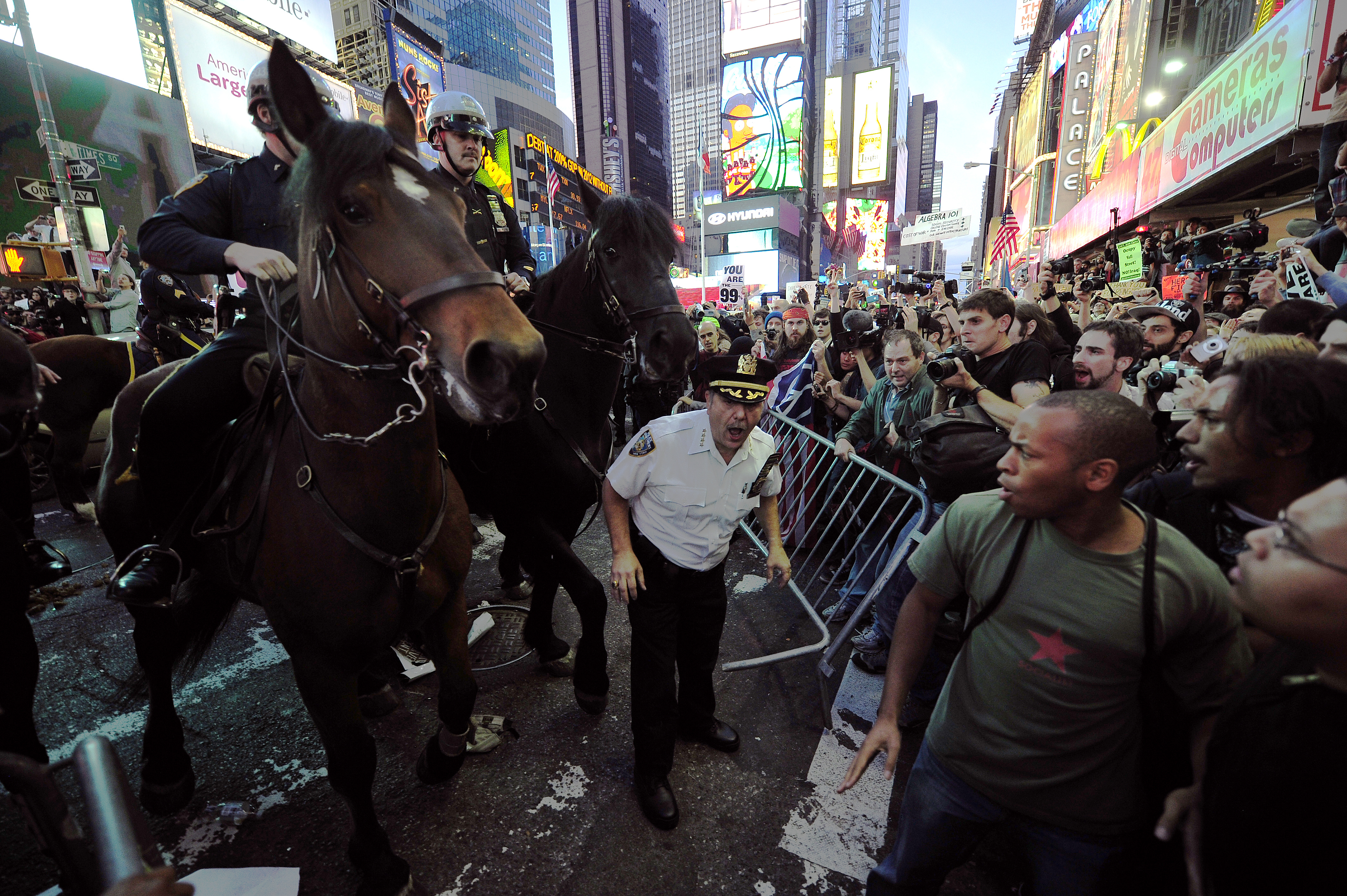 Mounted police stop Occupy Wall Street participants trying to break through police barricade set to stop them from taking their demonstration onto the street on Times Square in New York, October 15, 2011. As thousands of demonstrators protesting corporate greed filled Times Square, some 15 protestors were handcuffed and loaded into a police van following the confrontation with police. The Occupy Wall Street movement went global with groups from Asia to Europe, and in every US state, staging demonstrations and other actions. AFP PHOTO / Emmanuel Dunand (Photo credit should read EMMANUEL DUNAND/AFP/Getty Images)