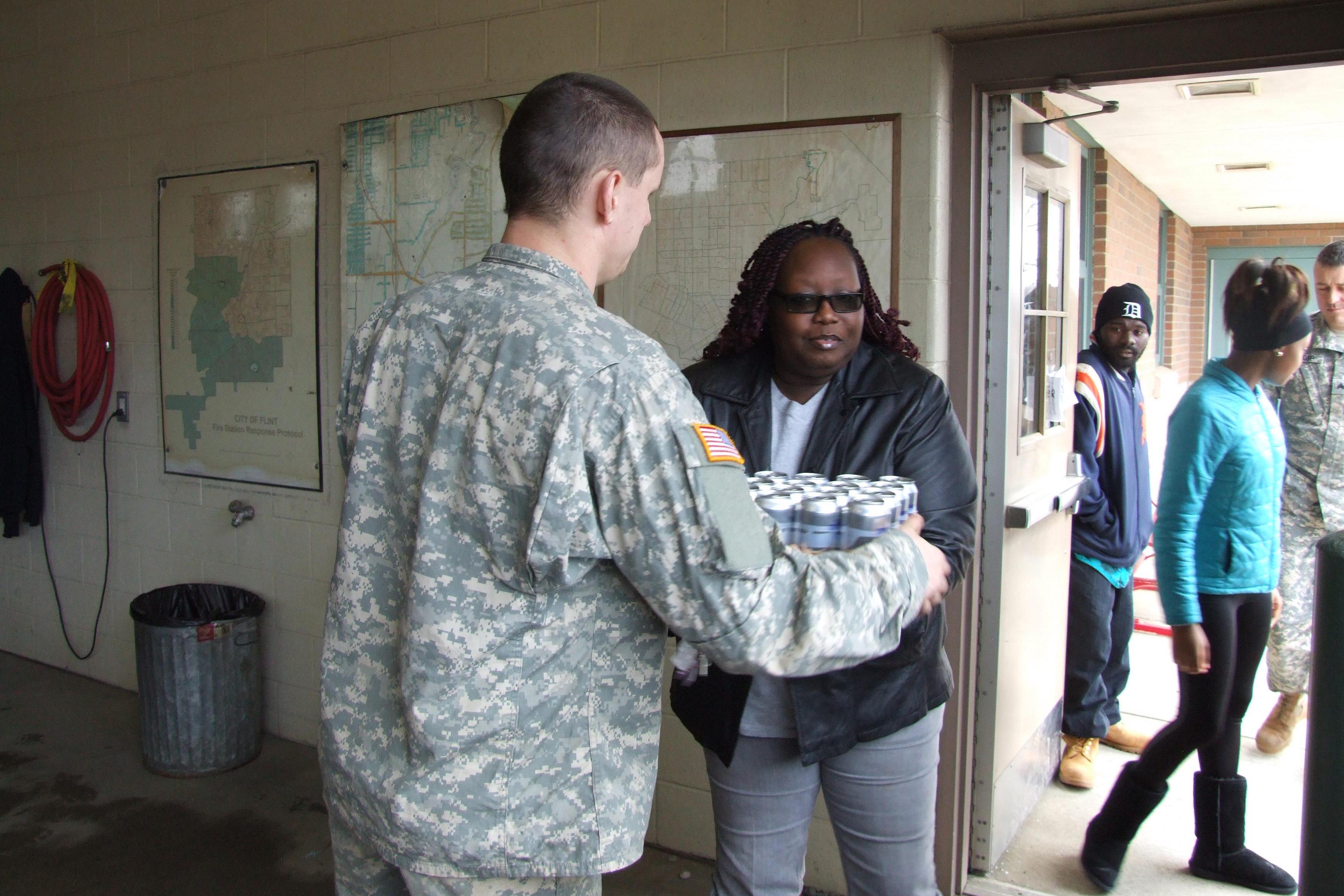 A Michigan National Guard member provides water to a Flint resident. CREDIT: Michigan National Guard